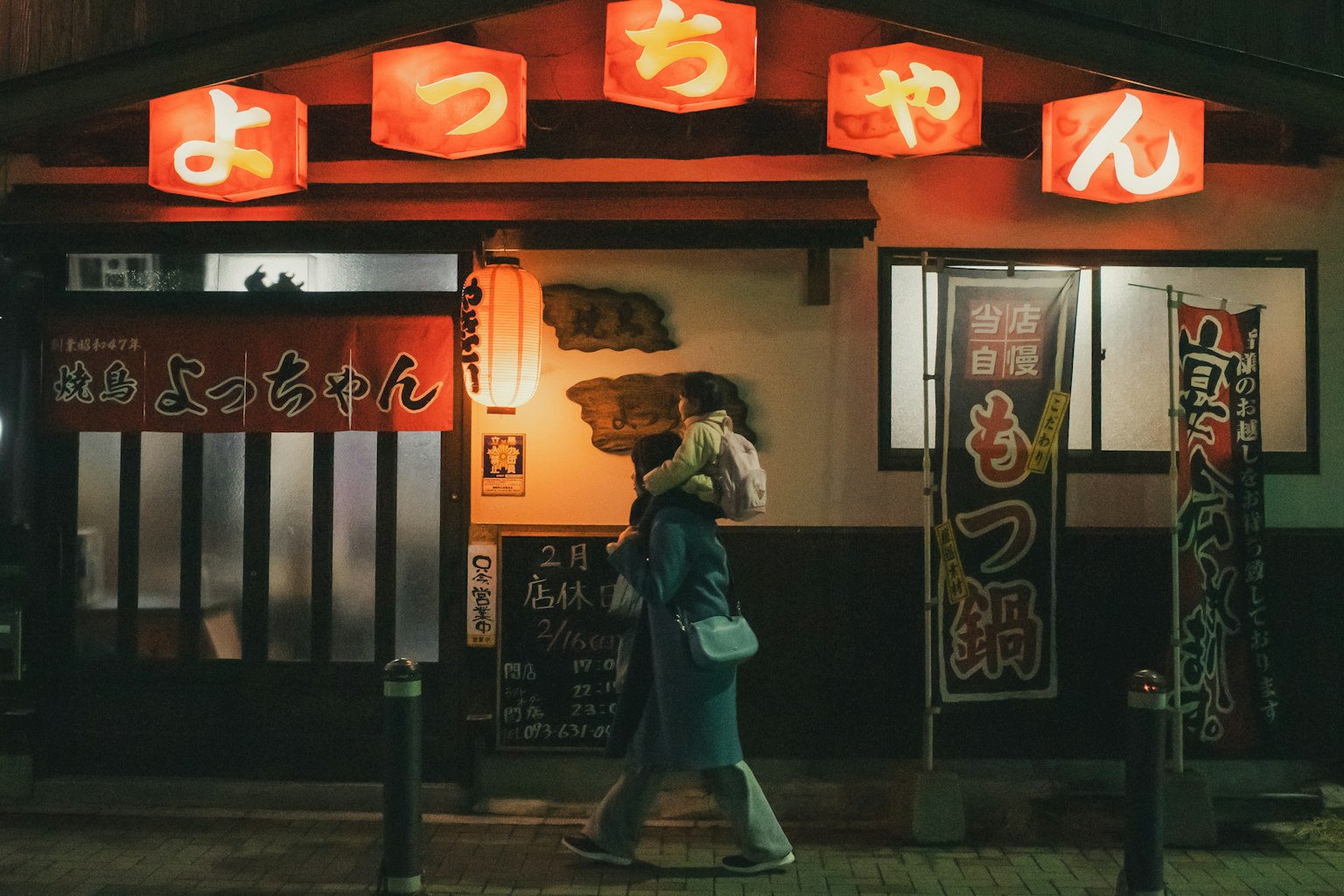 Exterior of a Japanese restaurant at night with striking red lanterns