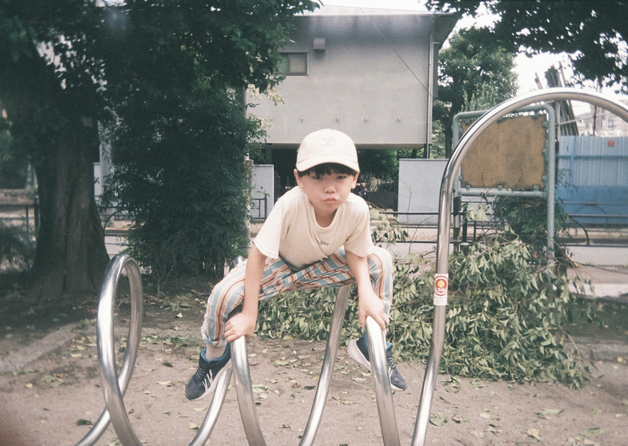 自転車の前に立つ帽子をかぶった子ども