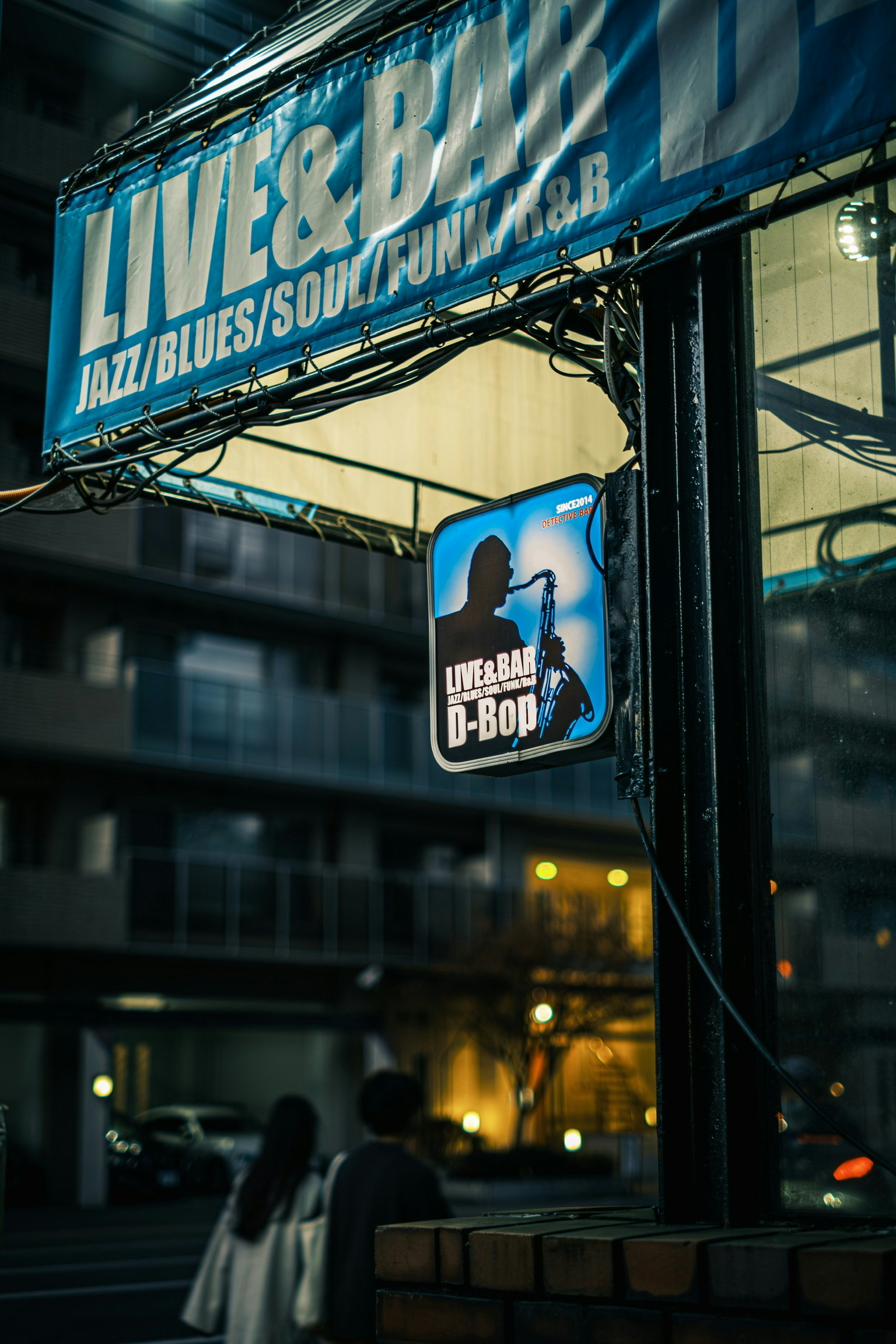 Insegna per un locale musicale dal vivo che presenta jazz e blues in un ambiente notturno