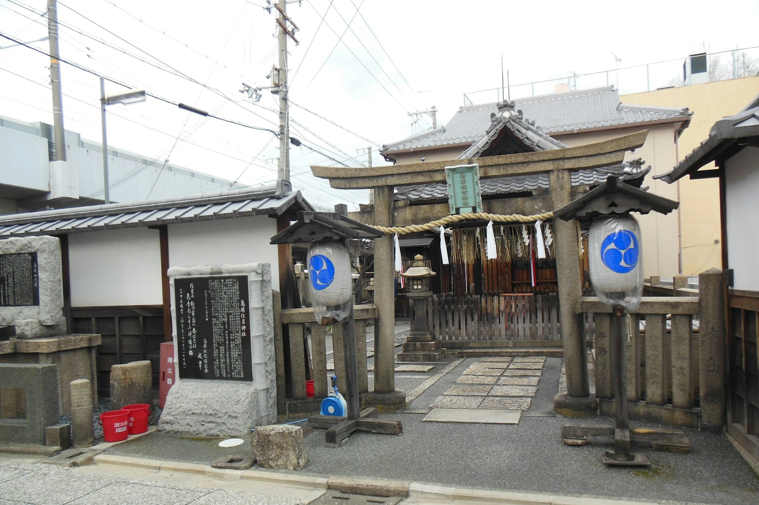 Entrance to a traditional shrine featuring stone gates and lanterns