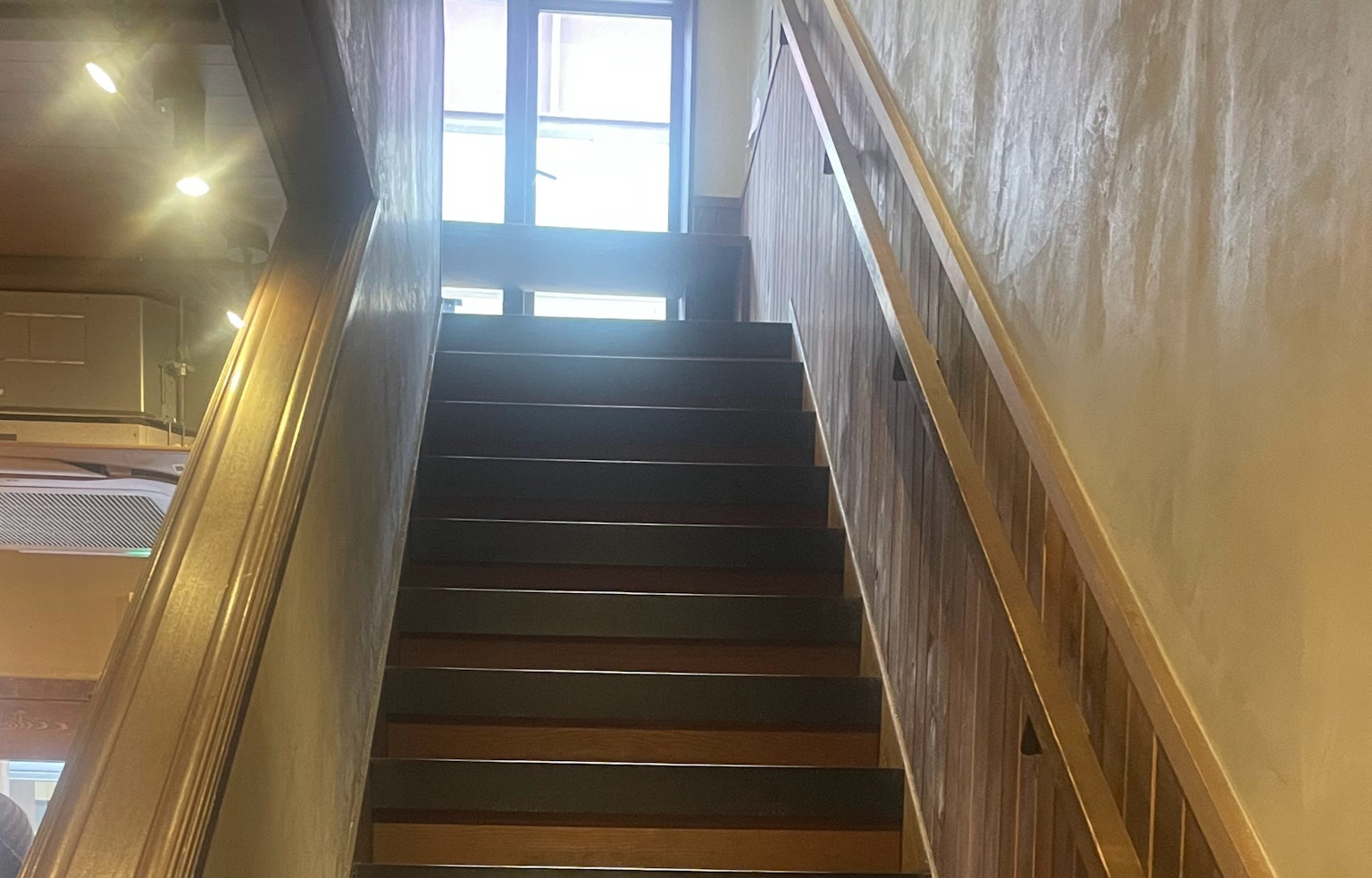 Foto interna di scale che conducono a una porta con finestre luminose