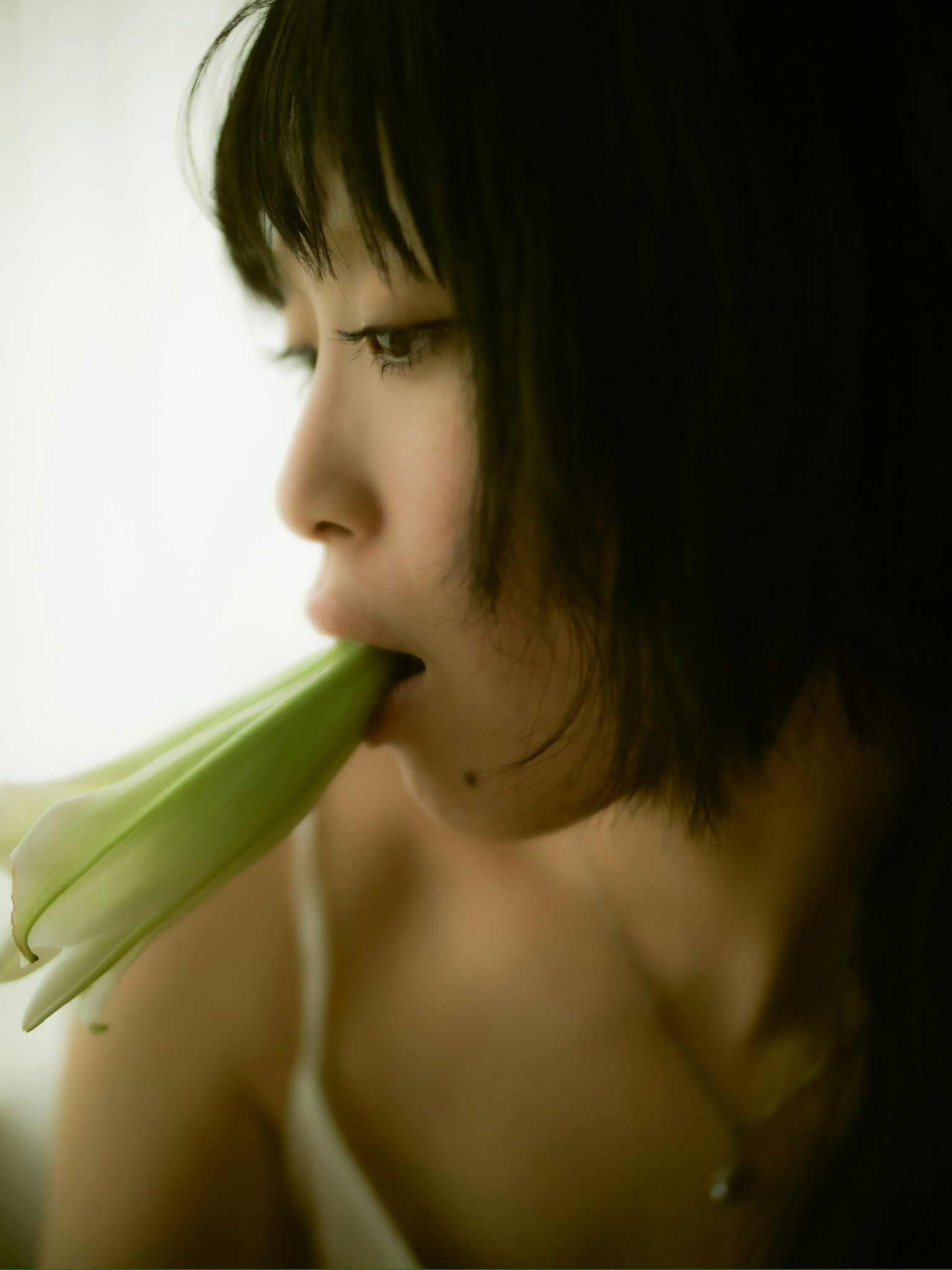 白色背景下侧脸微笑的女性特写