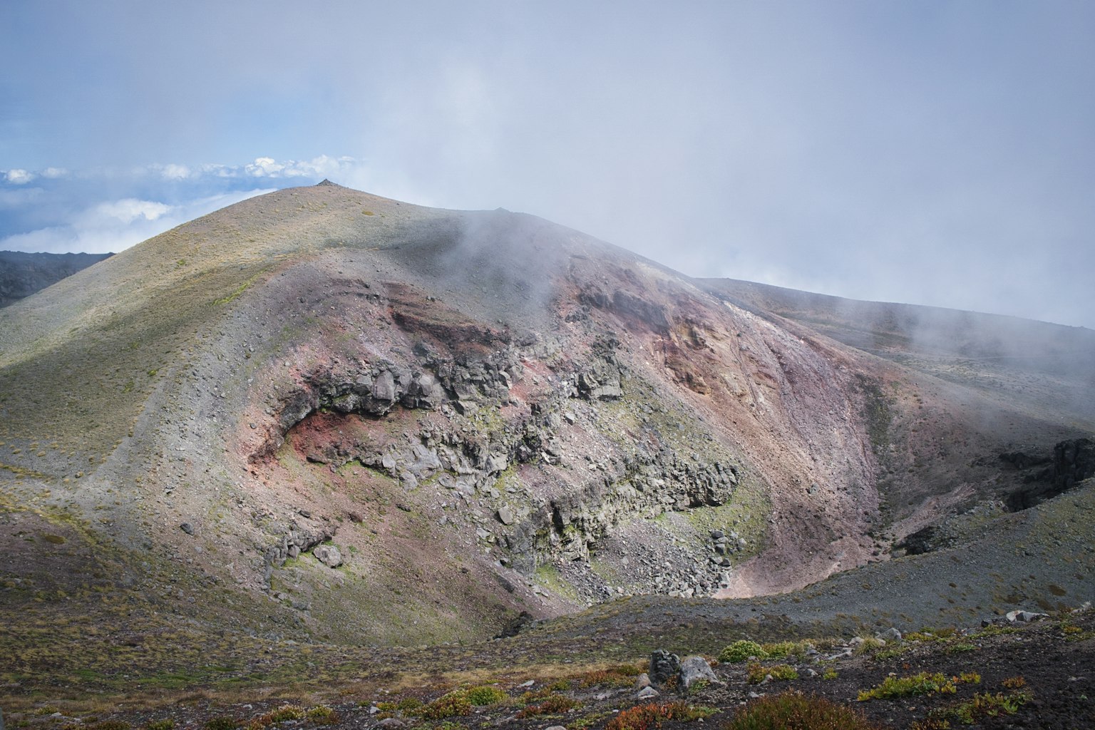 Volcanic mountain landscape with colorful layers and mist
