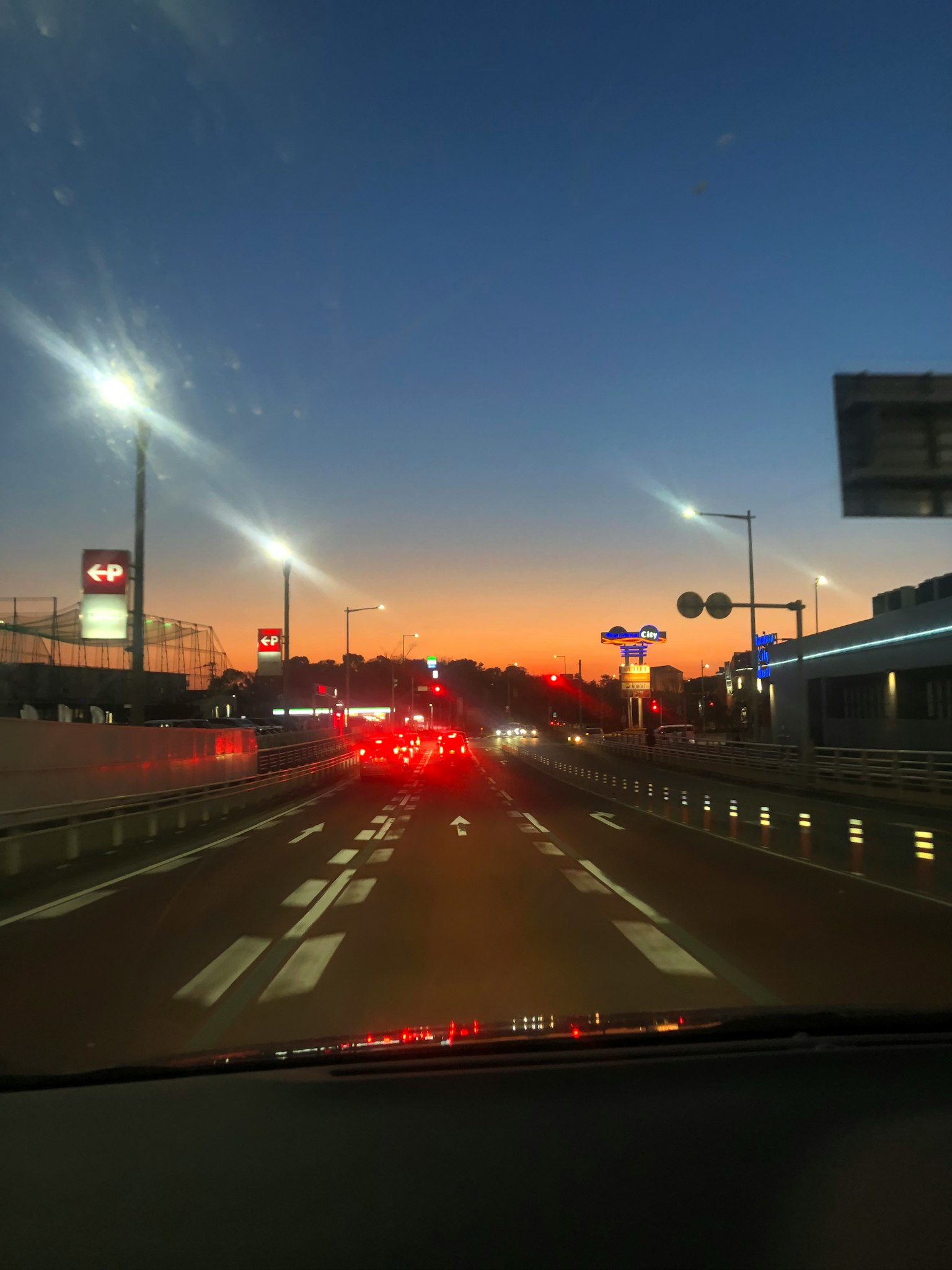 Route avec circulation sous un ciel de coucher de soleil