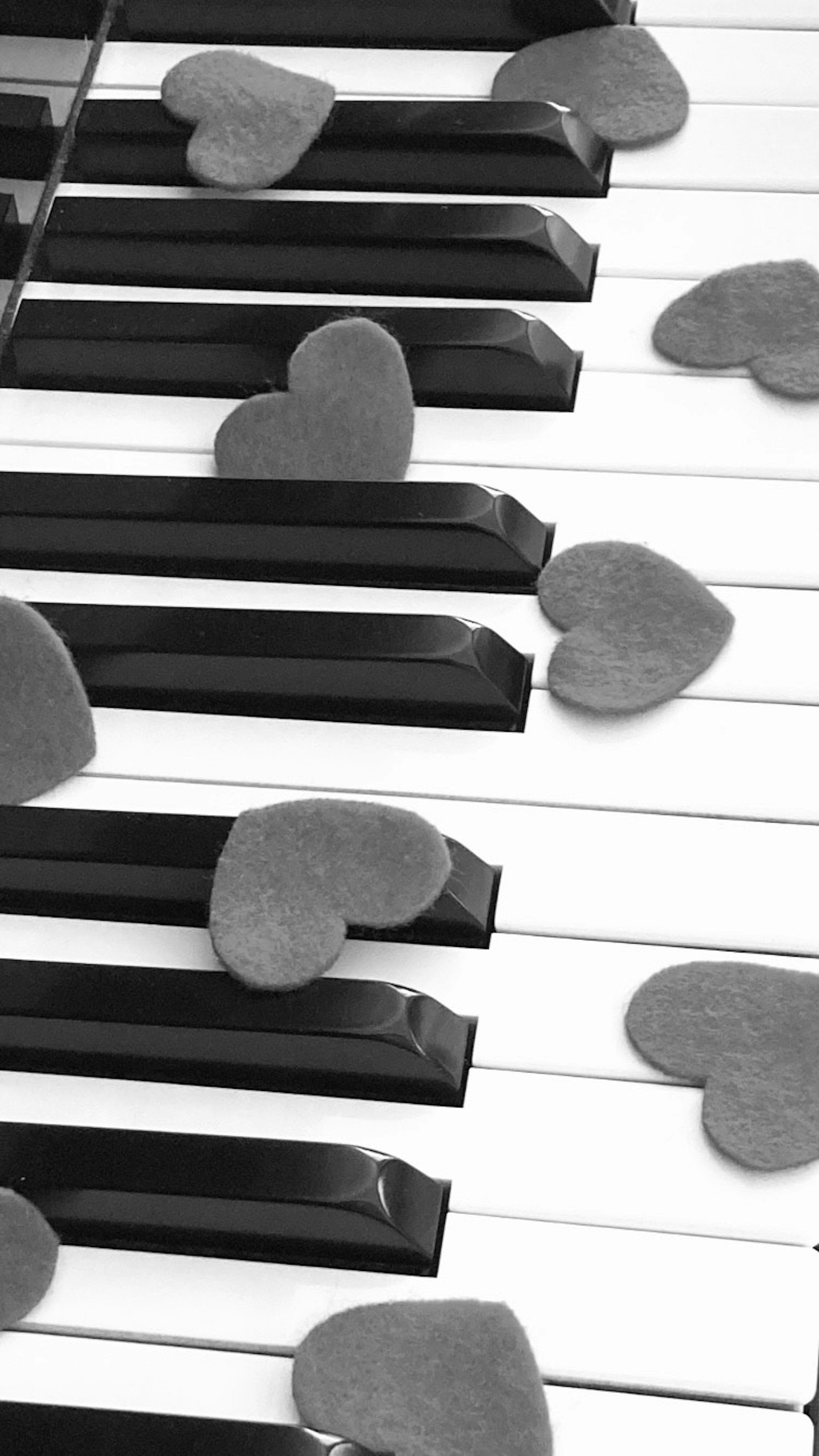 Pietre a forma di cuore posizionate sui tasti di un pianoforte