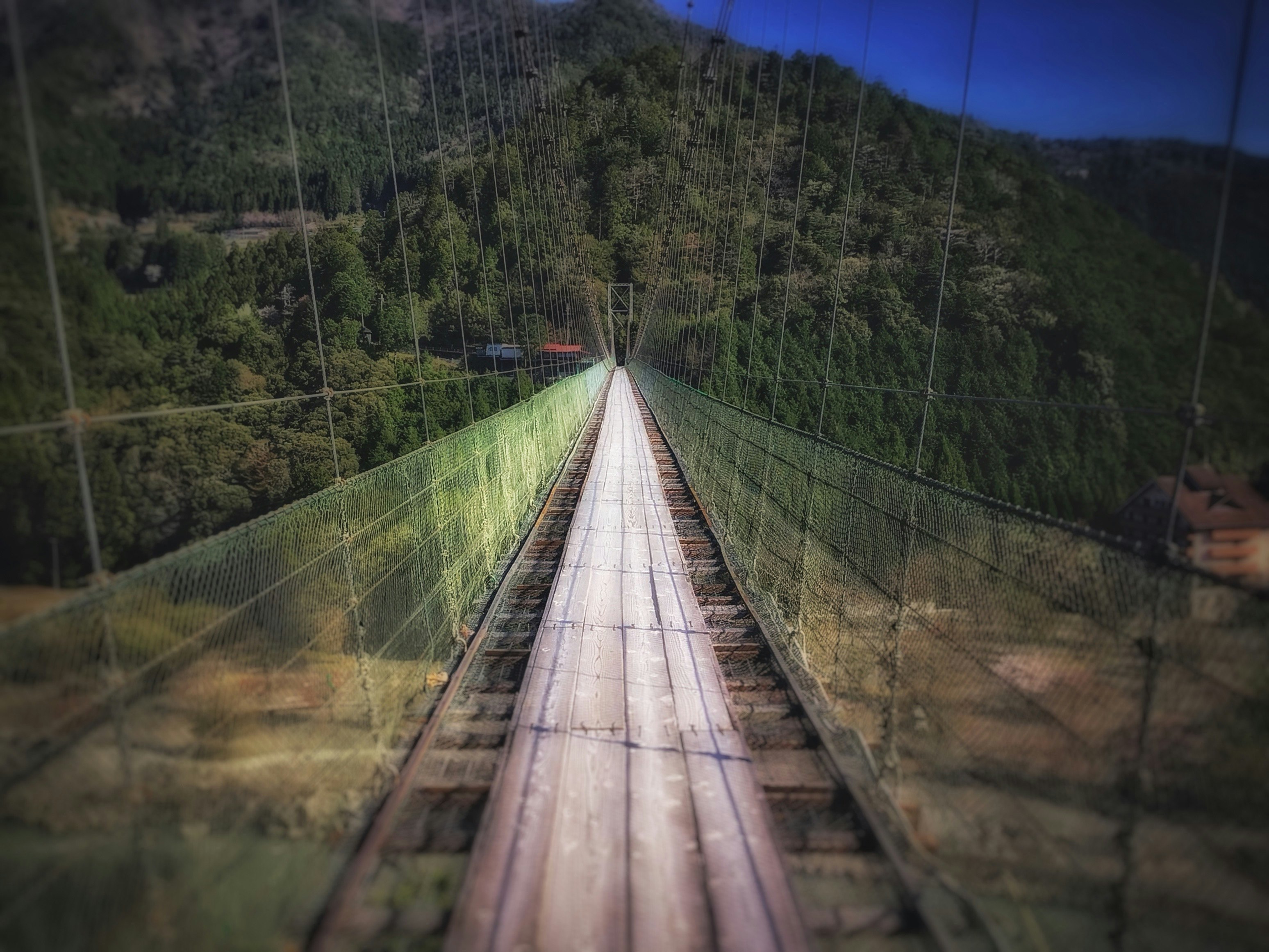 谷瀬の吊り橋の長い歩道と周囲の山並み