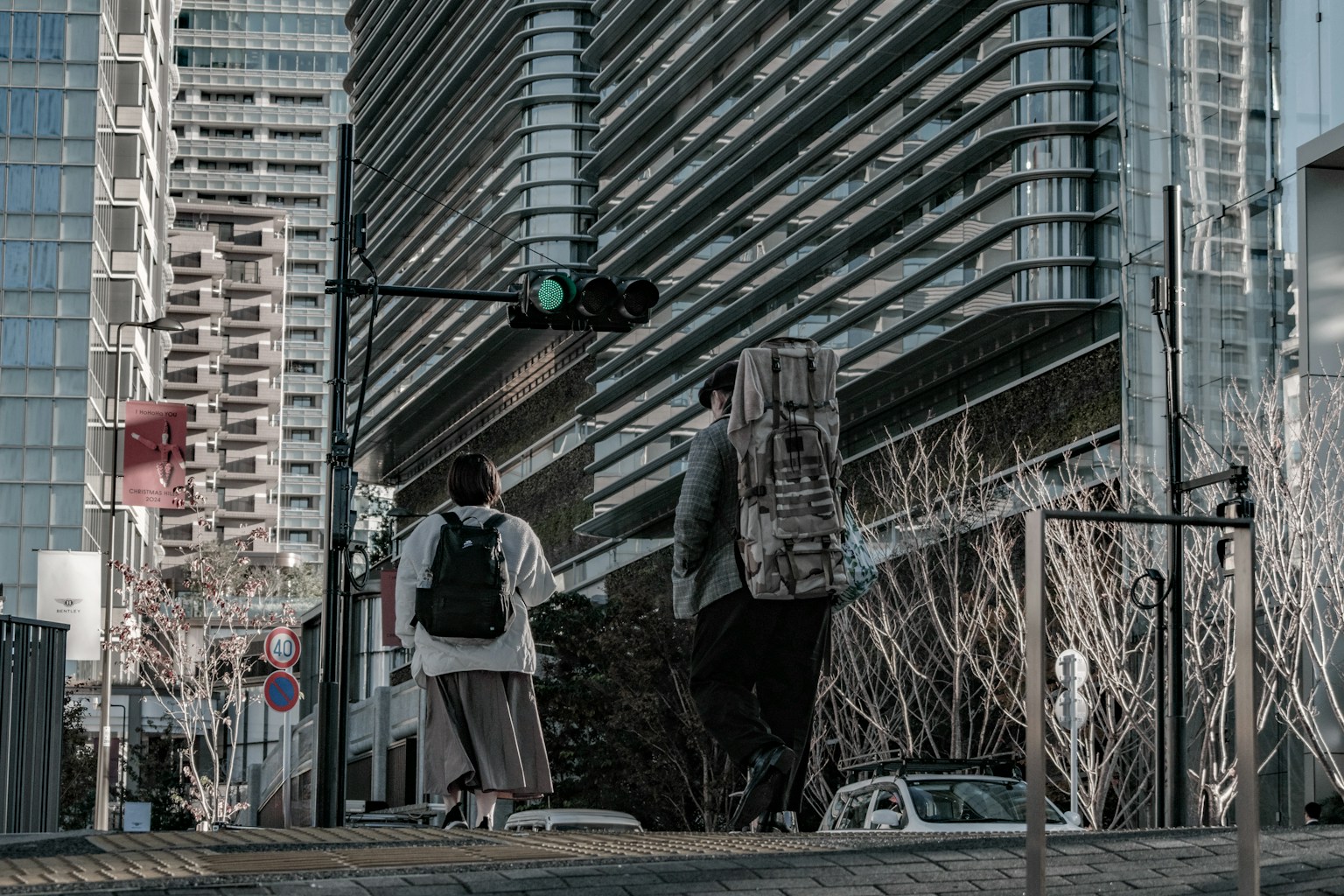 Two people walking in an urban setting with a green traffic light