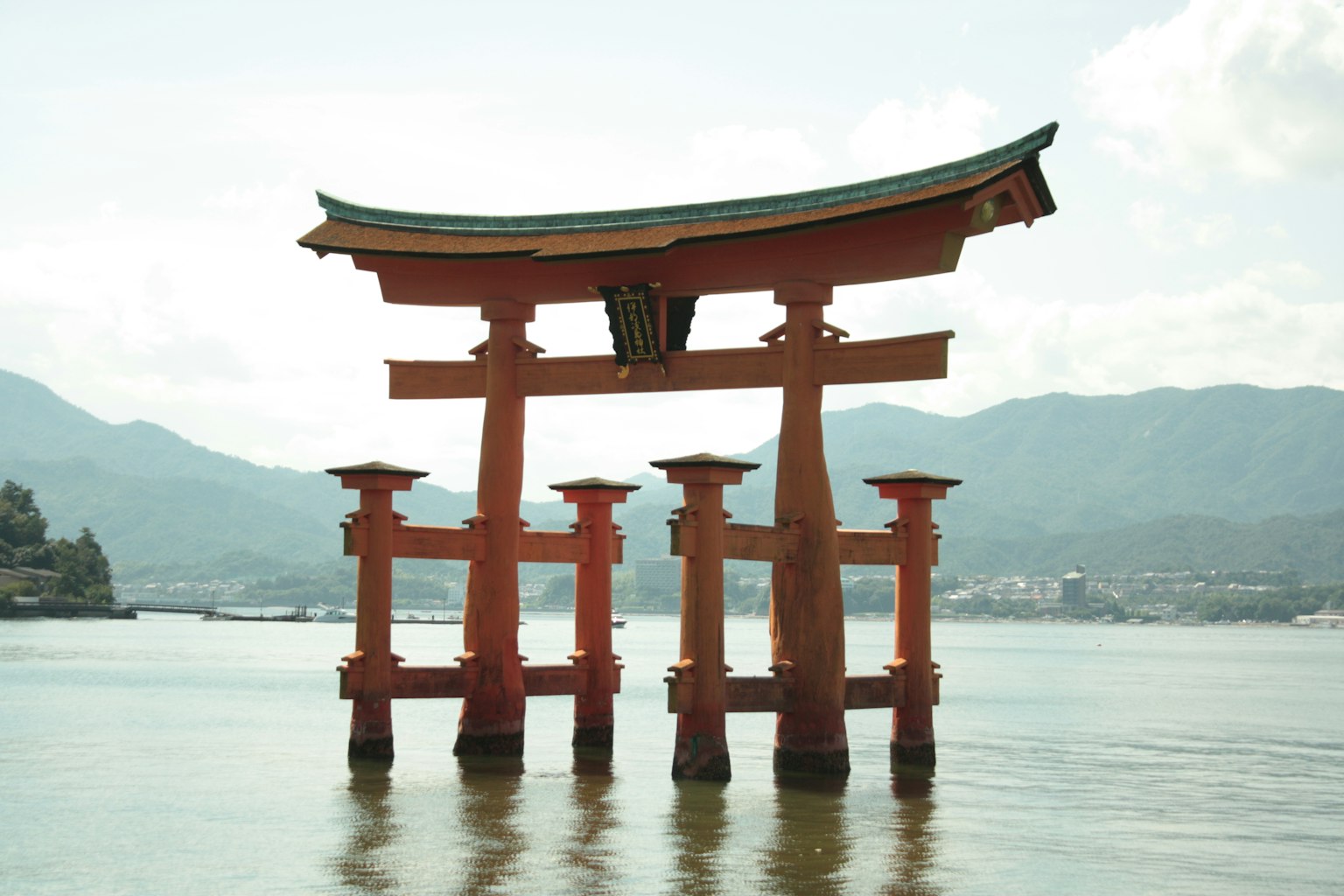 Rotes Torii in Wasser stehend mit Bergen im Hintergrund