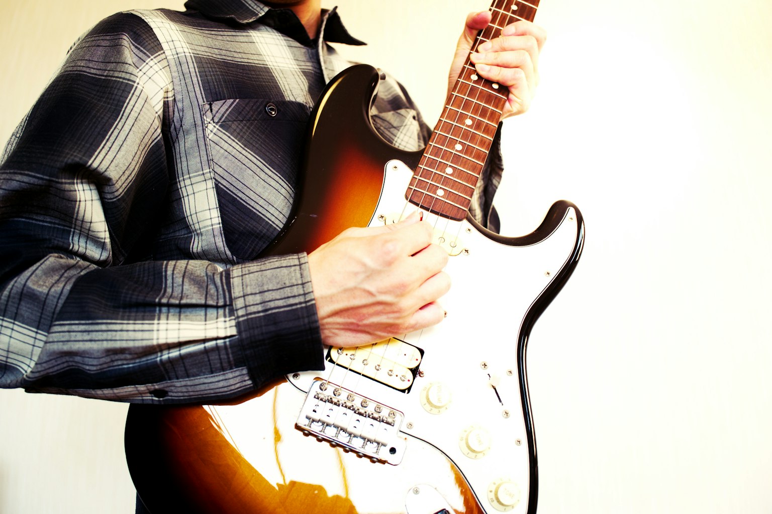 Primer plano de un hombre tocando una guitarra eléctrica