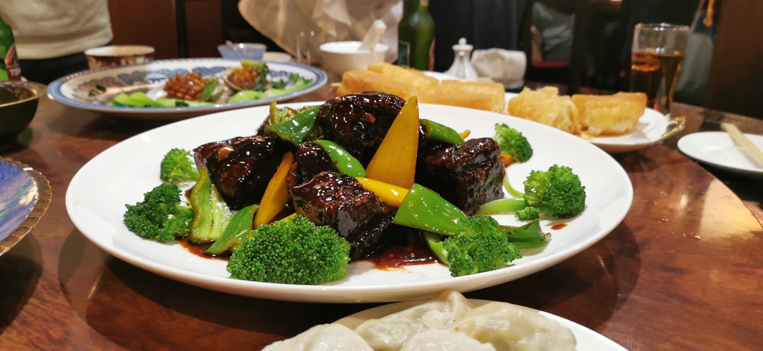 Un piatto ben presentato con broccoli e verdure colorate con pezzi di carne scura