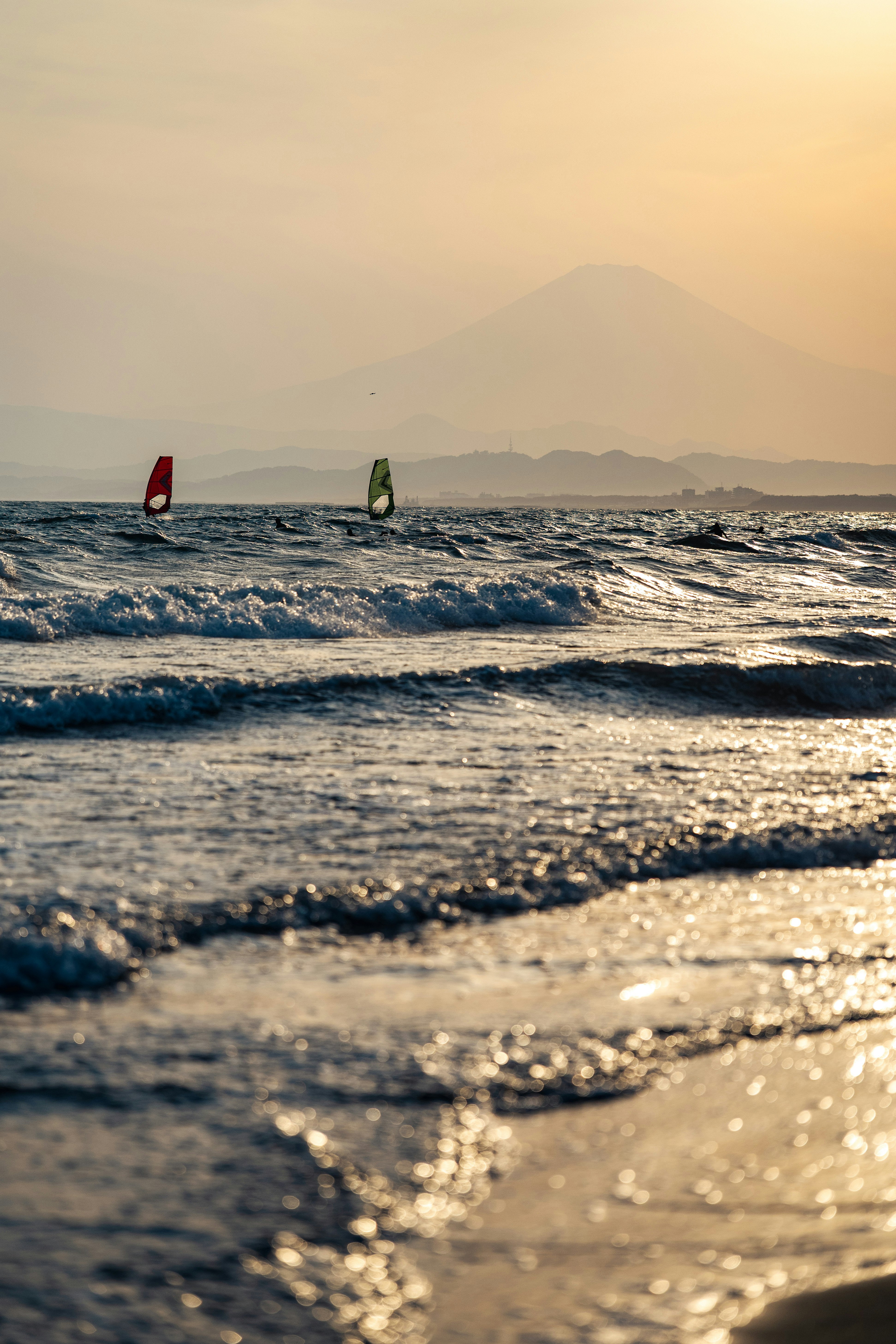 夕日に照らされた海面と沖のヨット
