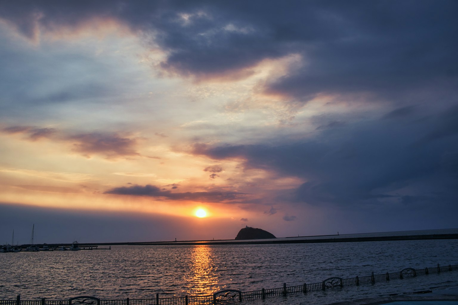 Schöner Sonnenuntergang über dem Meer mit einer Insel in der Ferne