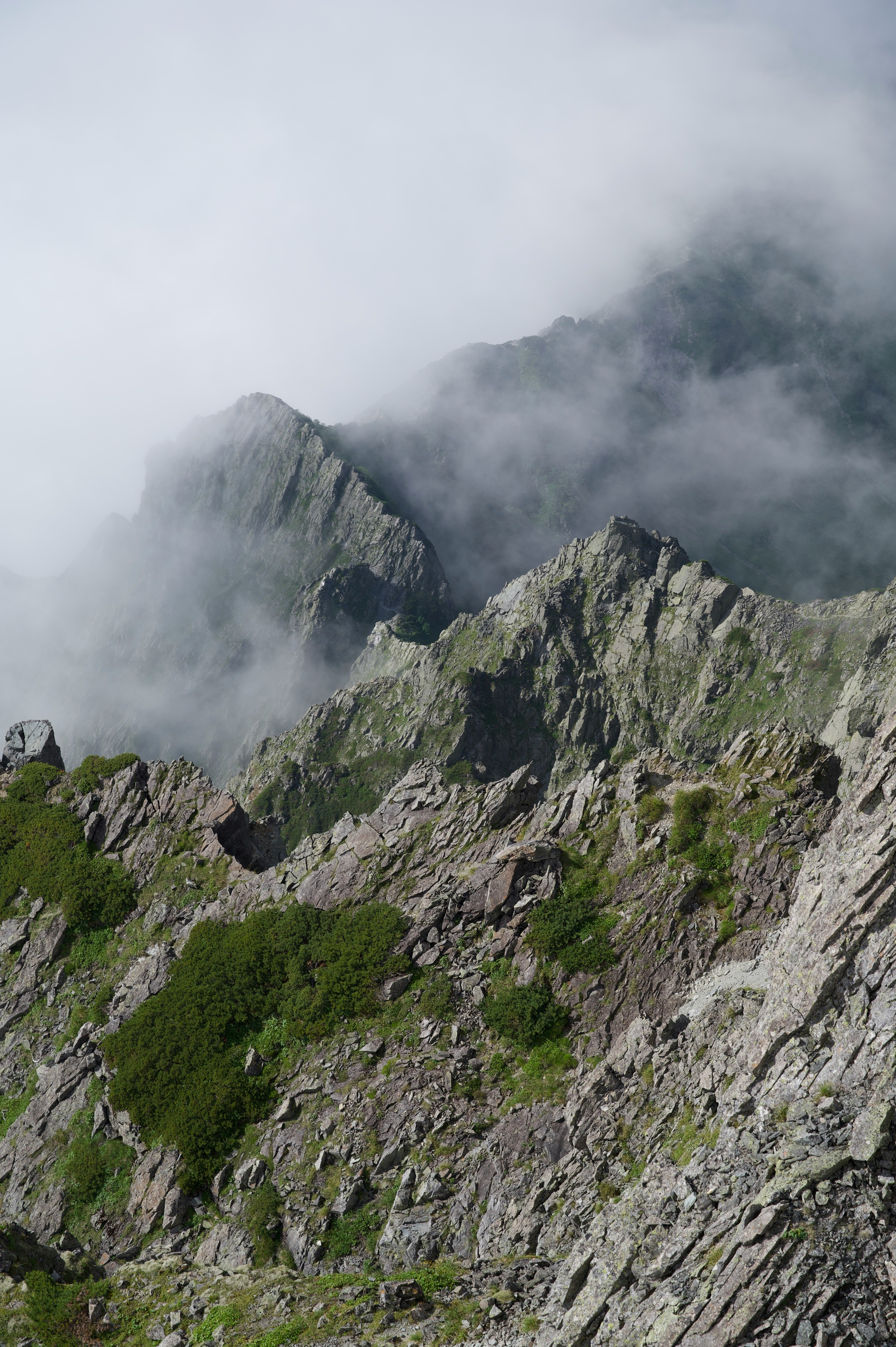 霧のかかった岩山の稜線と山肌の自然