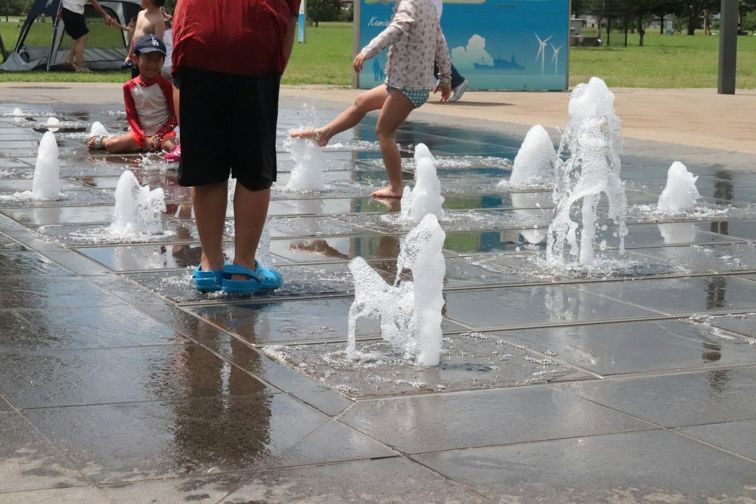 孩子們在公園的噴泉中玩耍