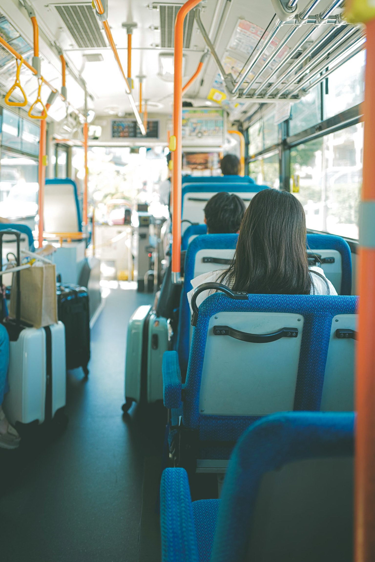 Vista interna di un autobus con sedili blu e bagagli