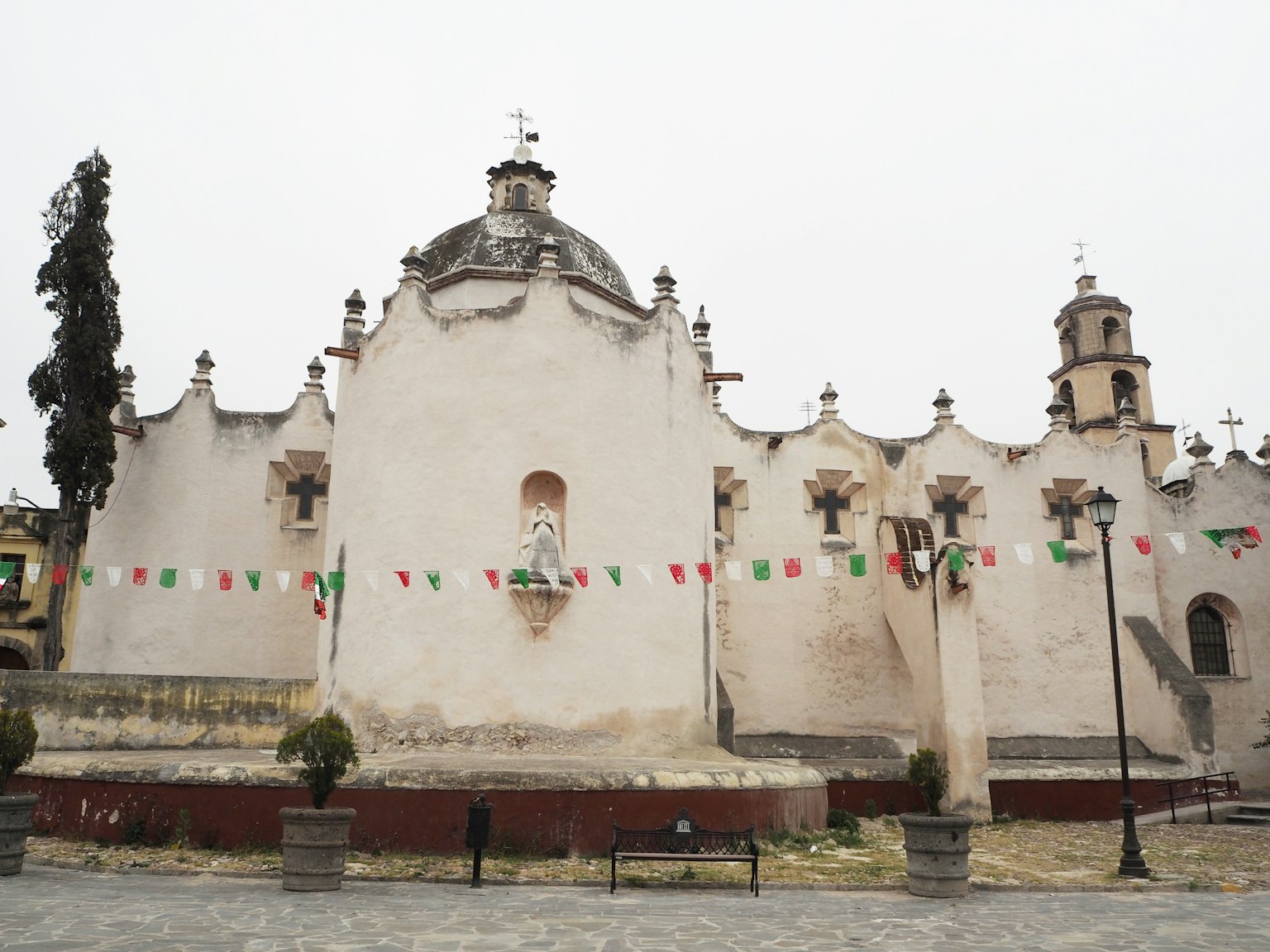 Esterno di una bella chiesa adornata con bandiere messicane