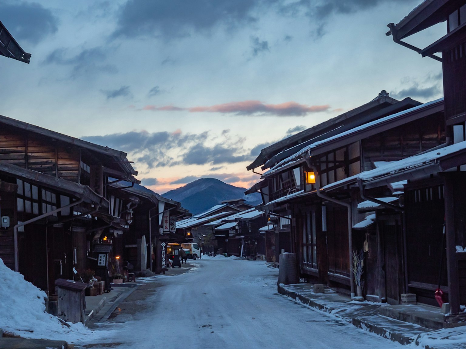 Jalan tradisional Jepang yang tertutup salju dengan langit senja
