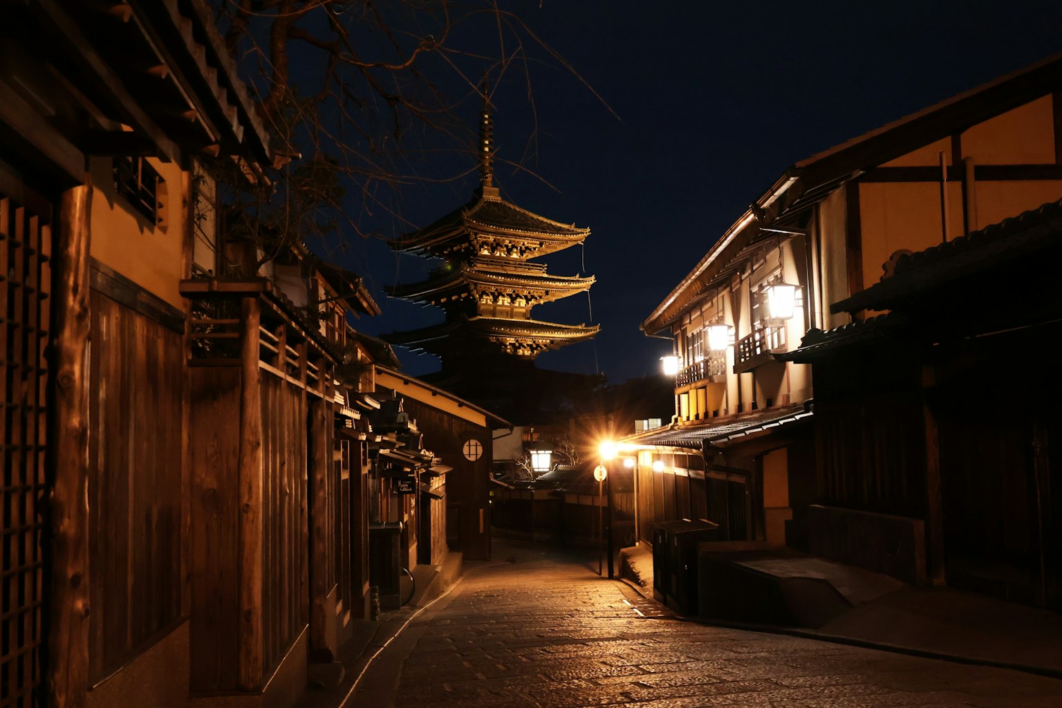 Vue nocturne d'une rue avec une pagode à cinq étages illuminée