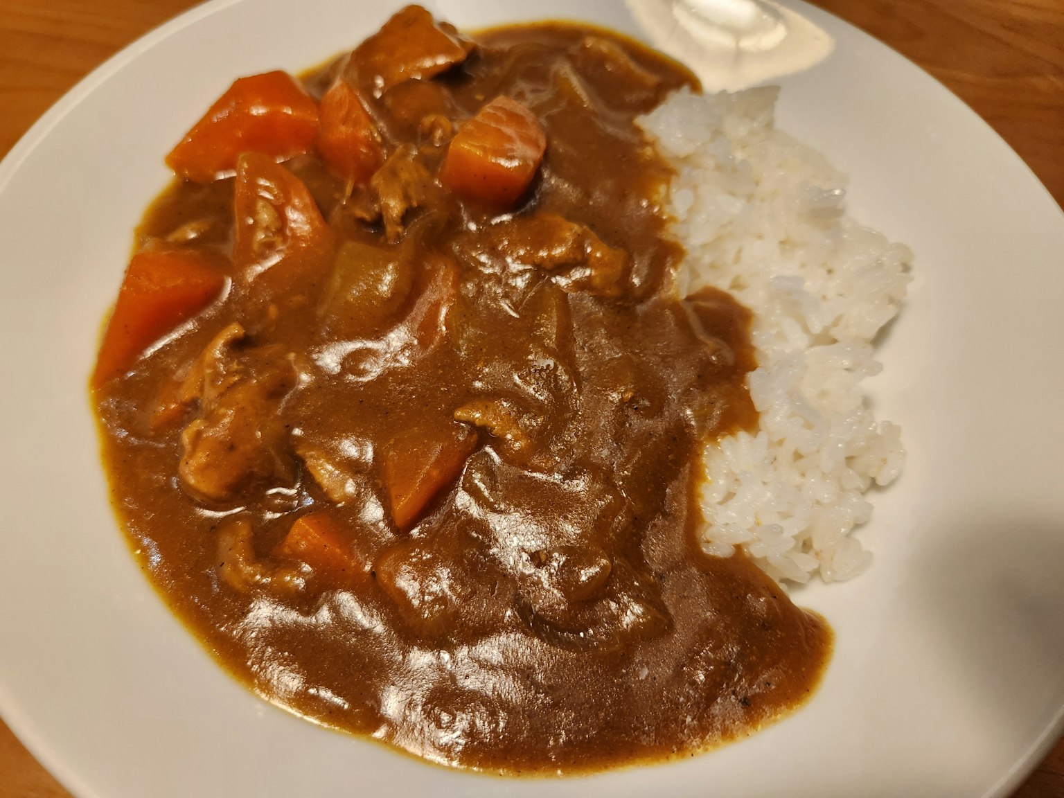 Leckeres Curryreis auf einem weißen Teller serviert
