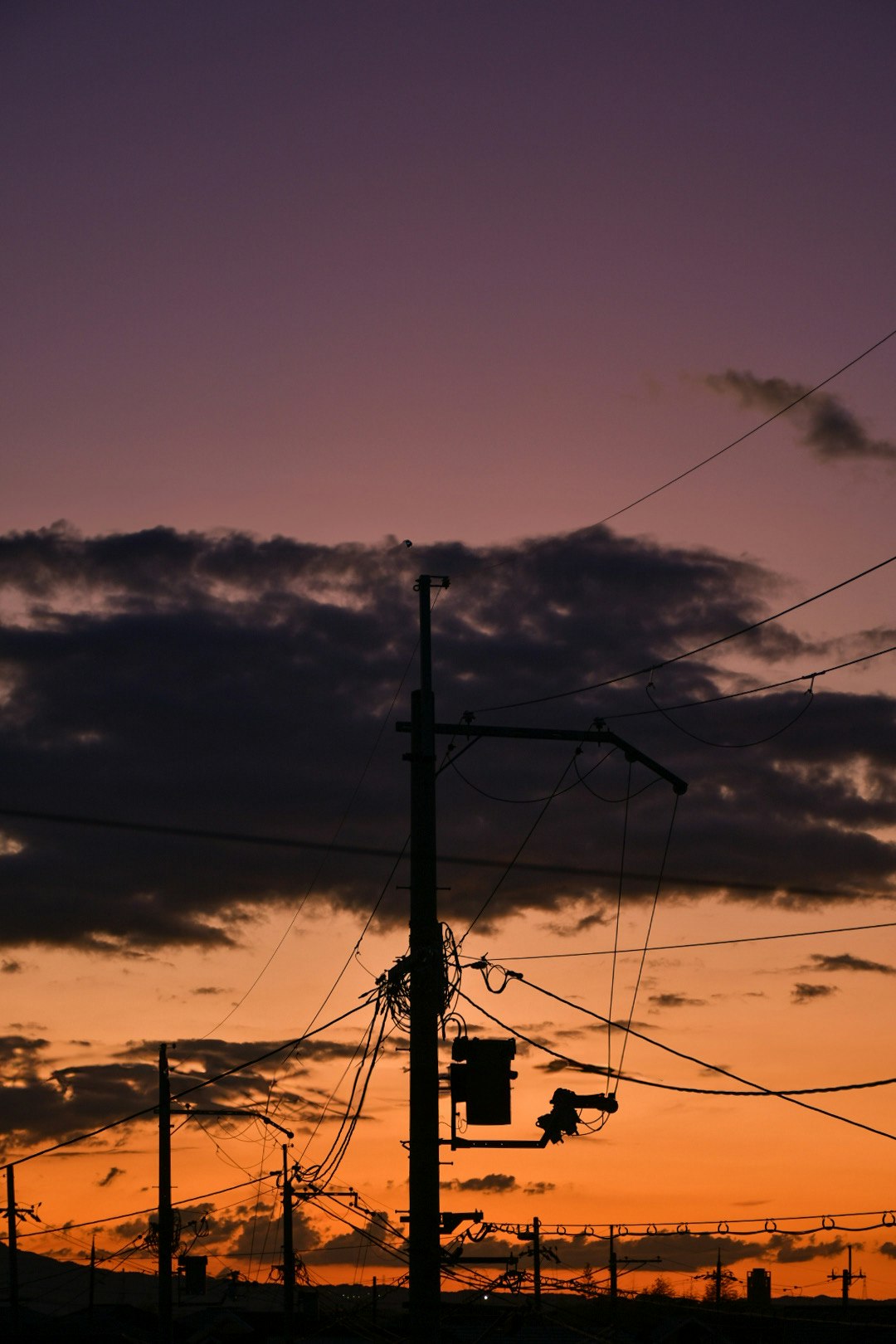 silhouettes de poteaux électriques et de câbles au-dessus d’un ciel de coucher de soleil