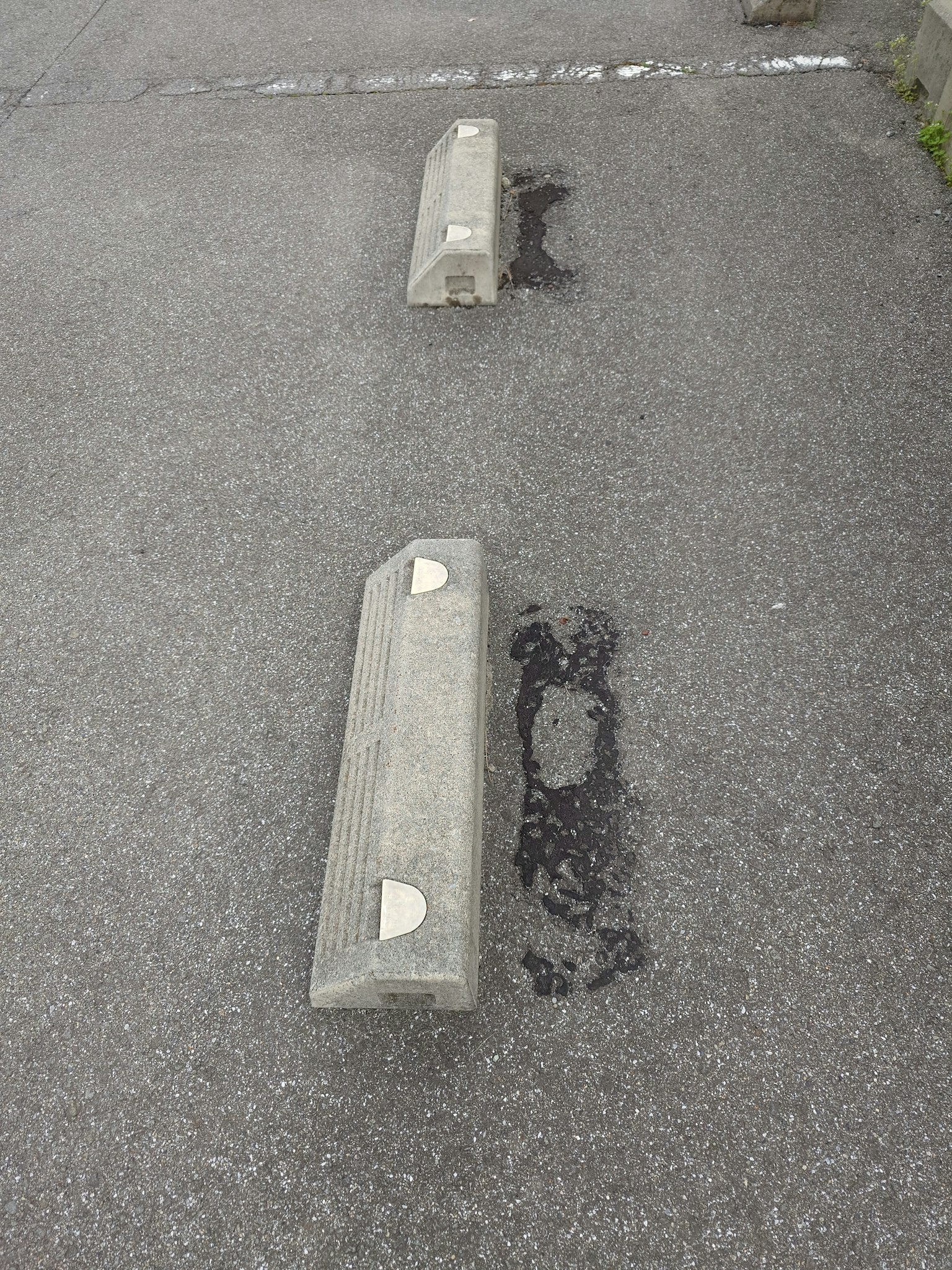 Borne de stationnement en béton sur une surface en asphalte gris