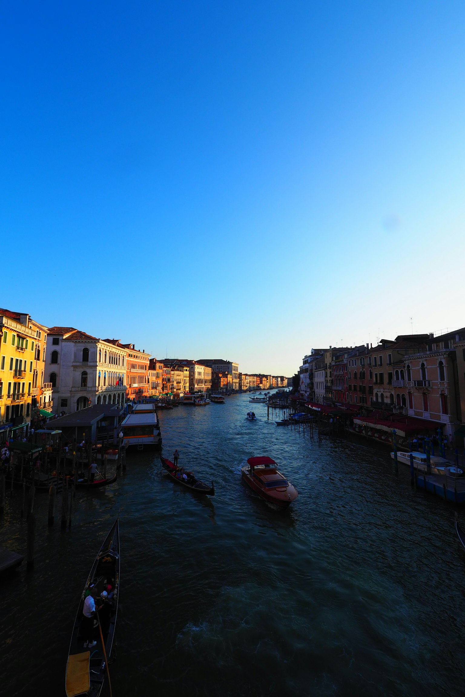 Paisaje veneciano con un canal bajo un cielo azul claro