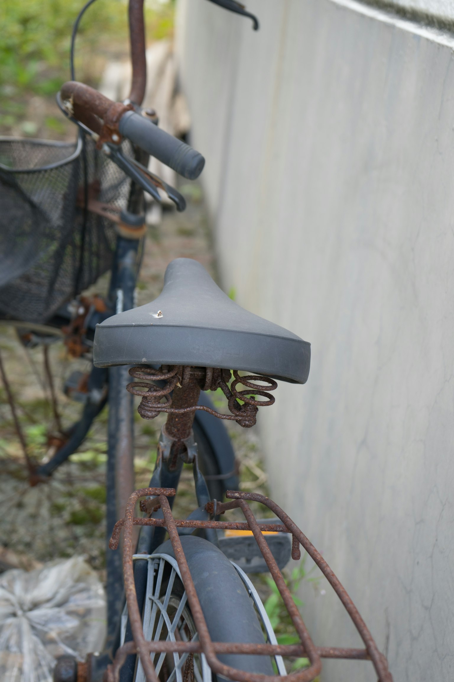 Close-up of an old bicycle seat and frame showing rust and wear