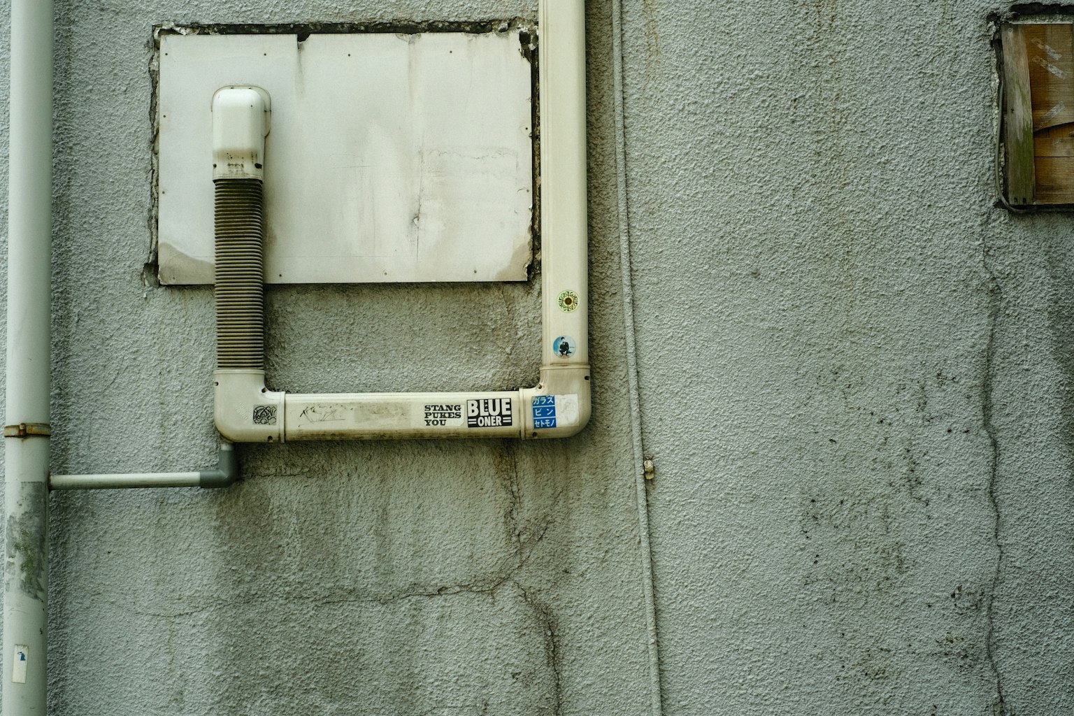 Immagine di tubi bianchi e pannello quadrato montato su un muro