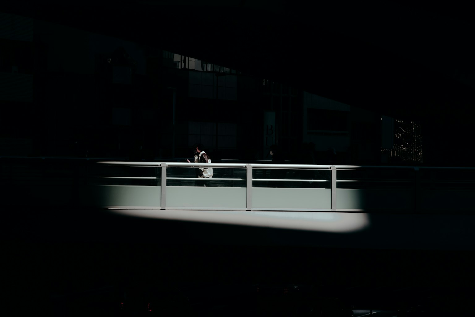明亮的欄杆與黑暗背景形成對比的場景