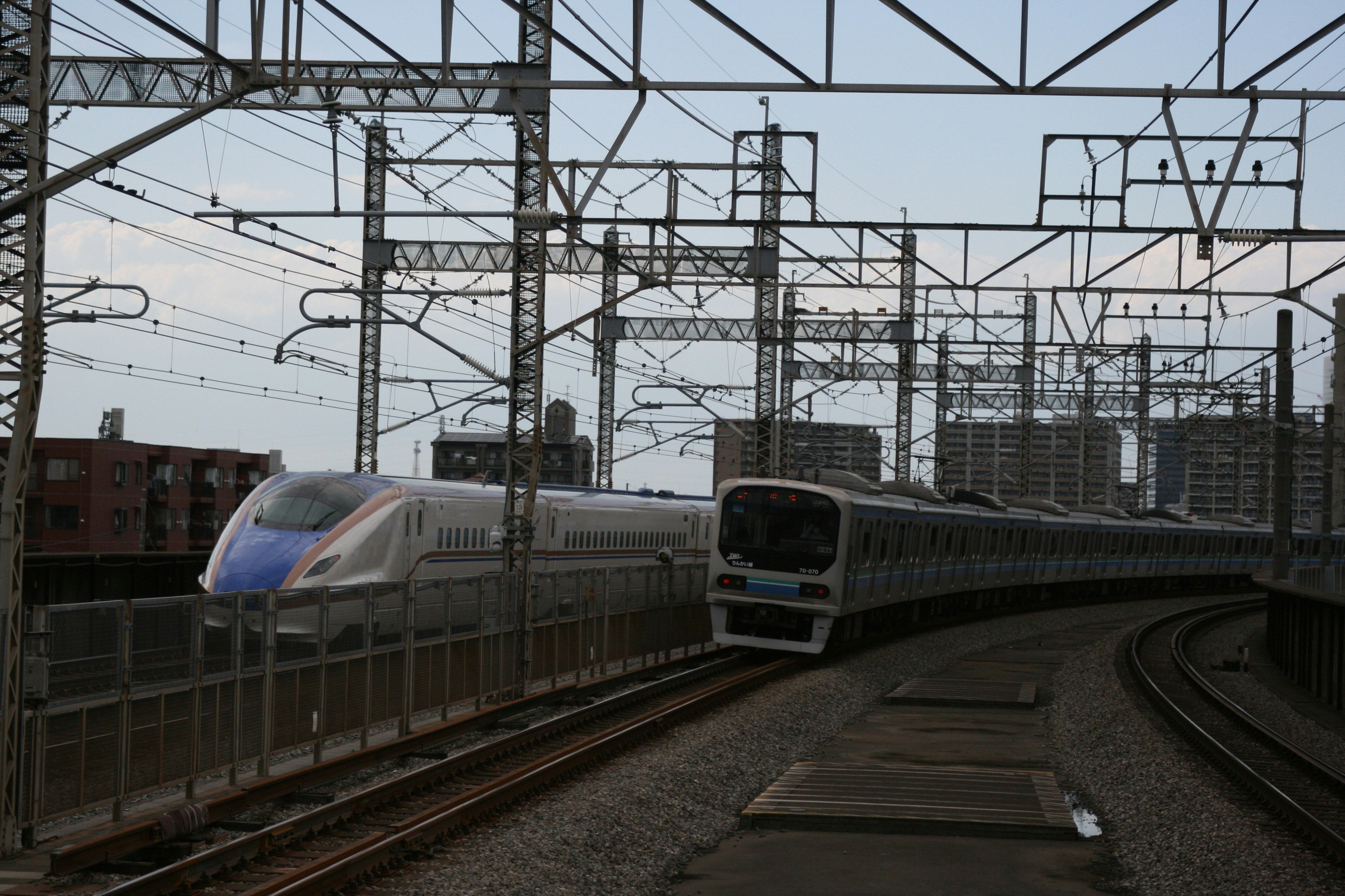 高架線路を走る電車のある鉄道駅のホーム風景