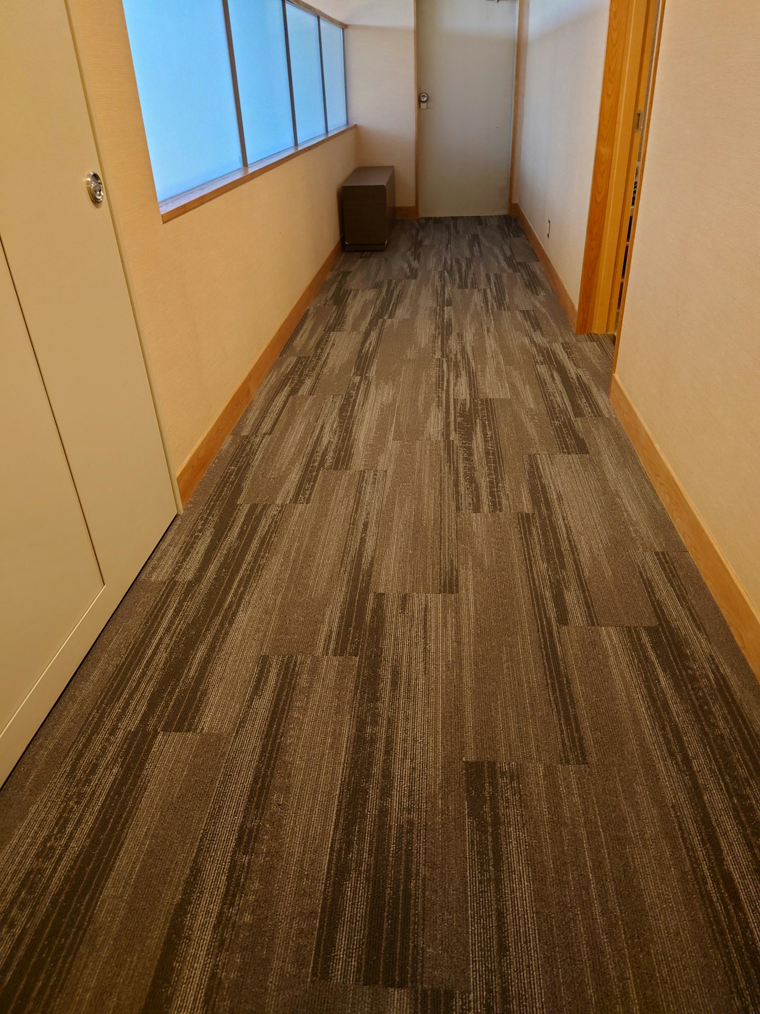 Corridoio luminoso con pavimento in legno e finestre