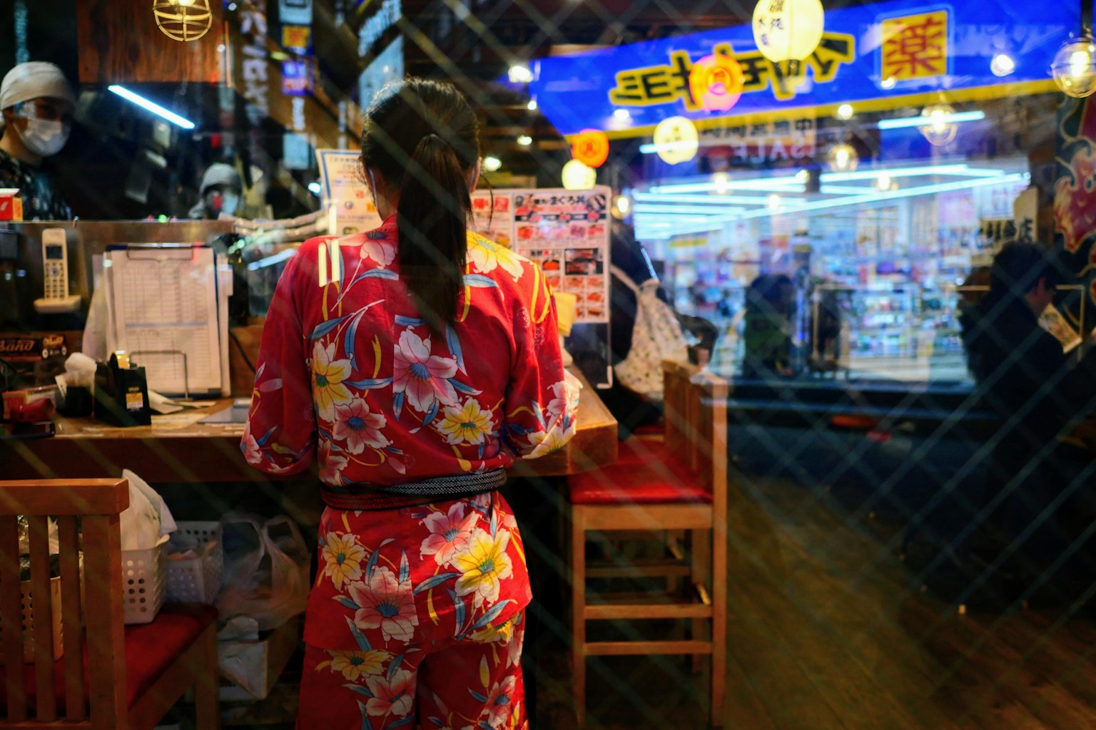 Eine Frau in einem bunten Kimono bereitet Essen an einem Straßenstand vor