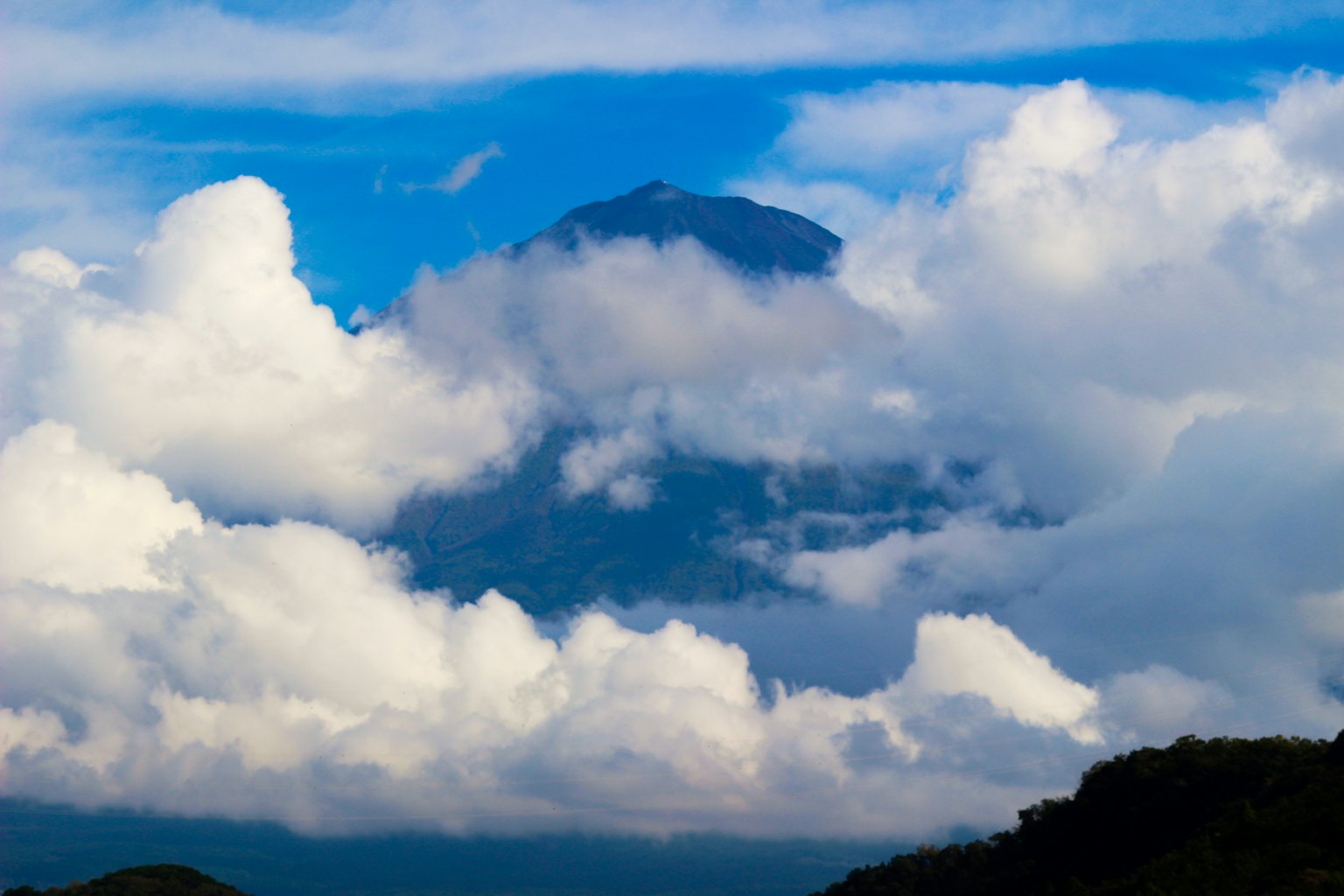 Paysage de montagne partiellement obscurci par des nuages ciel bleu et nuages blancs