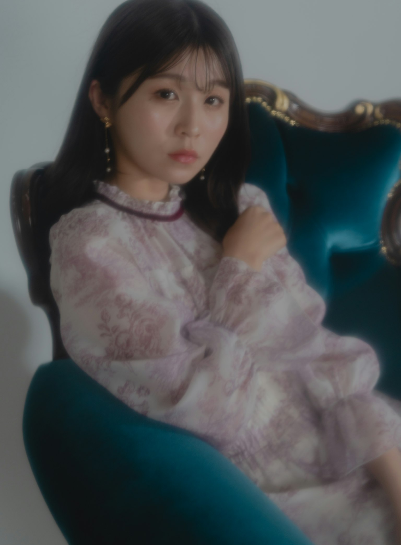 Une femme en robe violette assise sur une chaise bleue