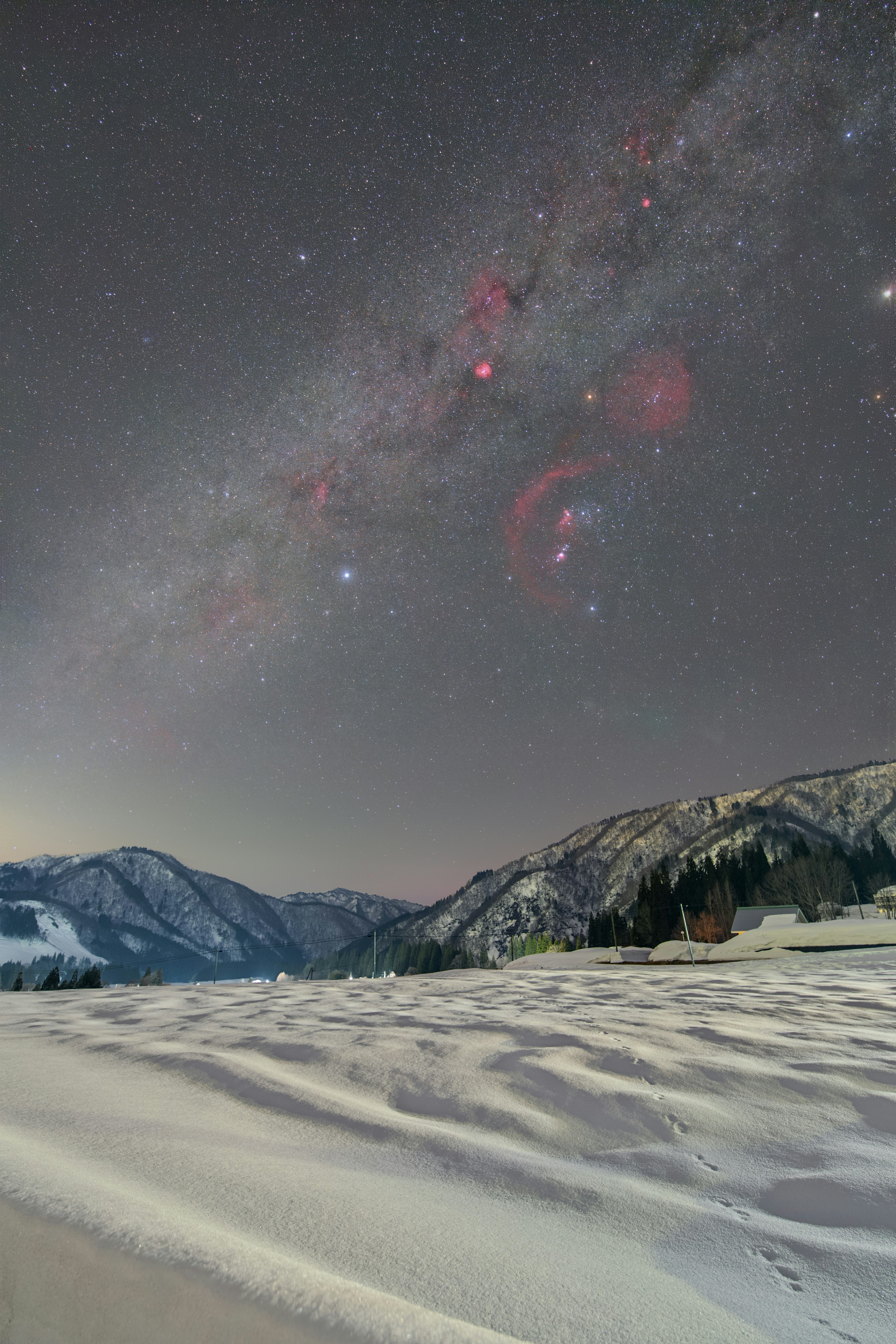 雪原の上に広がる冬の天の川と星空