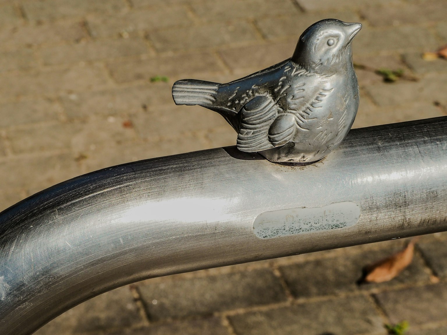 Eine Metallschmuckvogelfigur auf einem Rohr