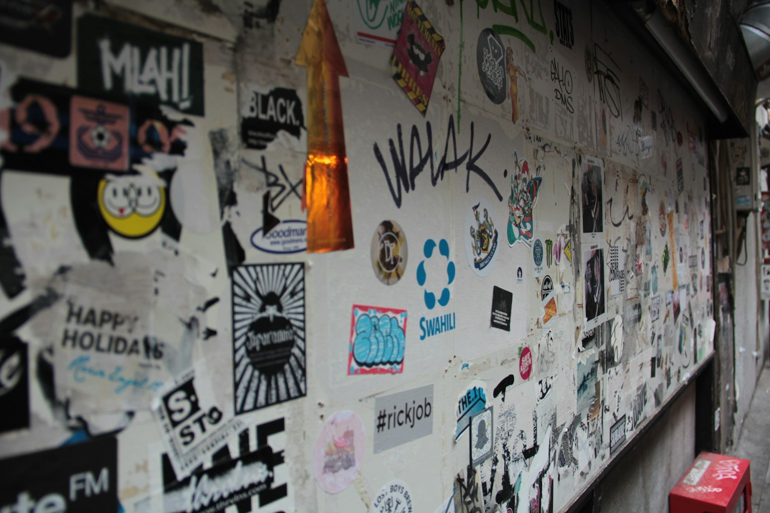 Gambar dengan berbagai stiker dan grafiti di dinding