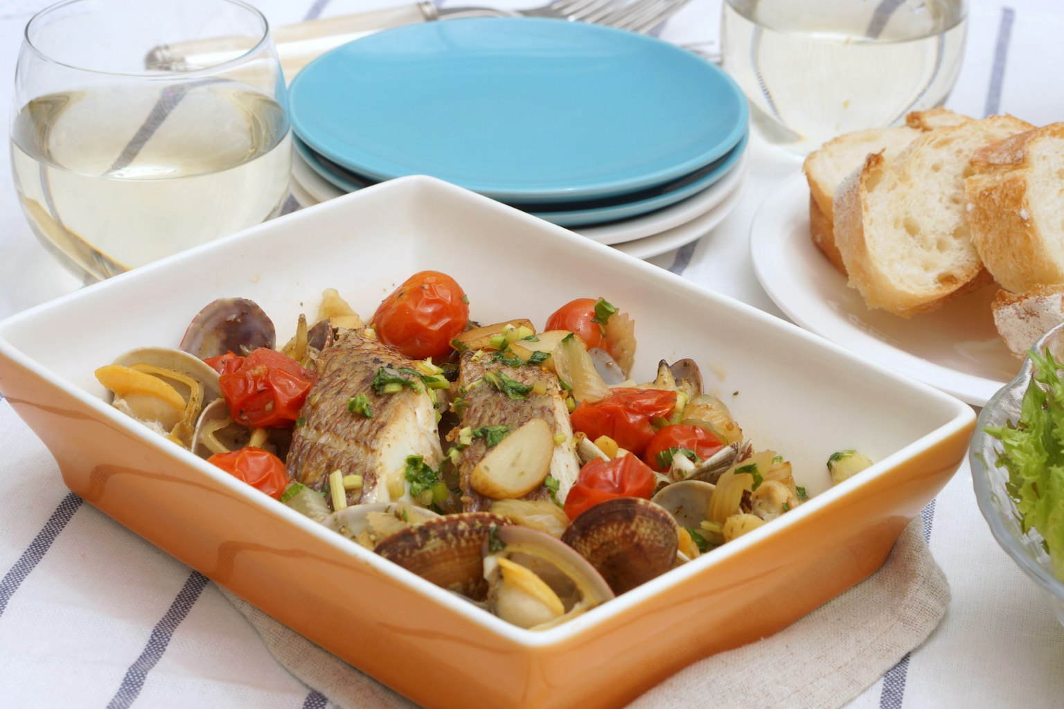 Seafood dish served in a ceramic dish with fresh tomatoes and herbs