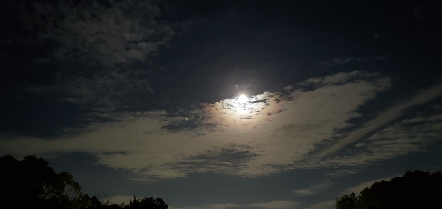 明亮的滿月被雲環繞在夜空中