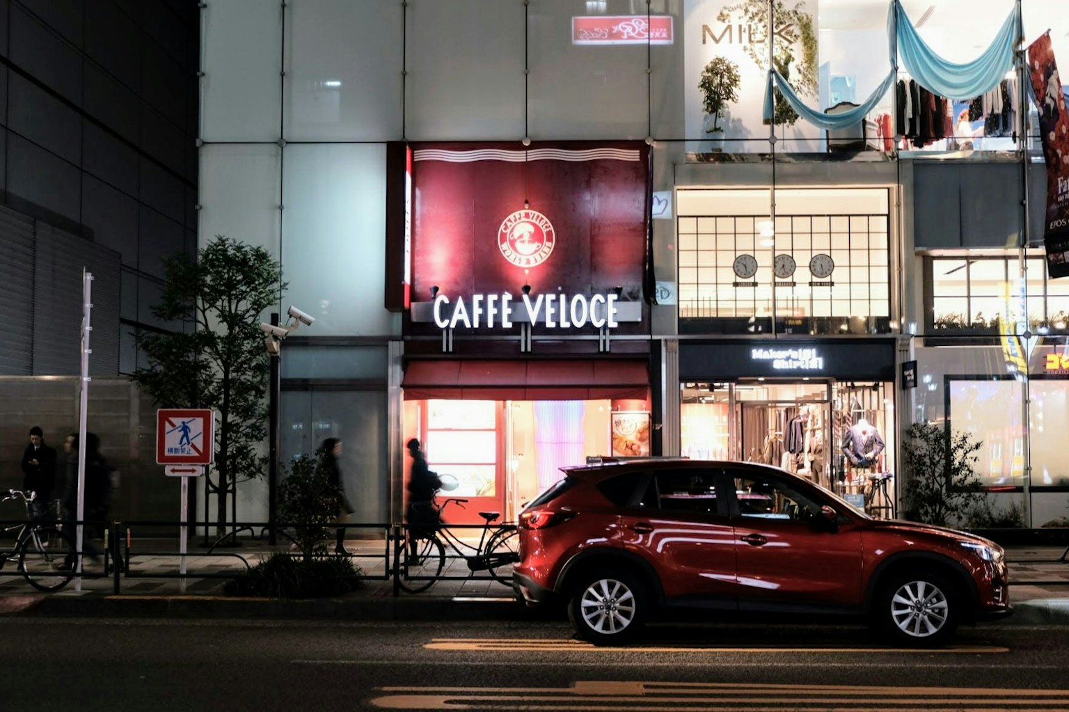 Caffe Veloce-Schild mit einem roten Auto, das in der Nähe parkt