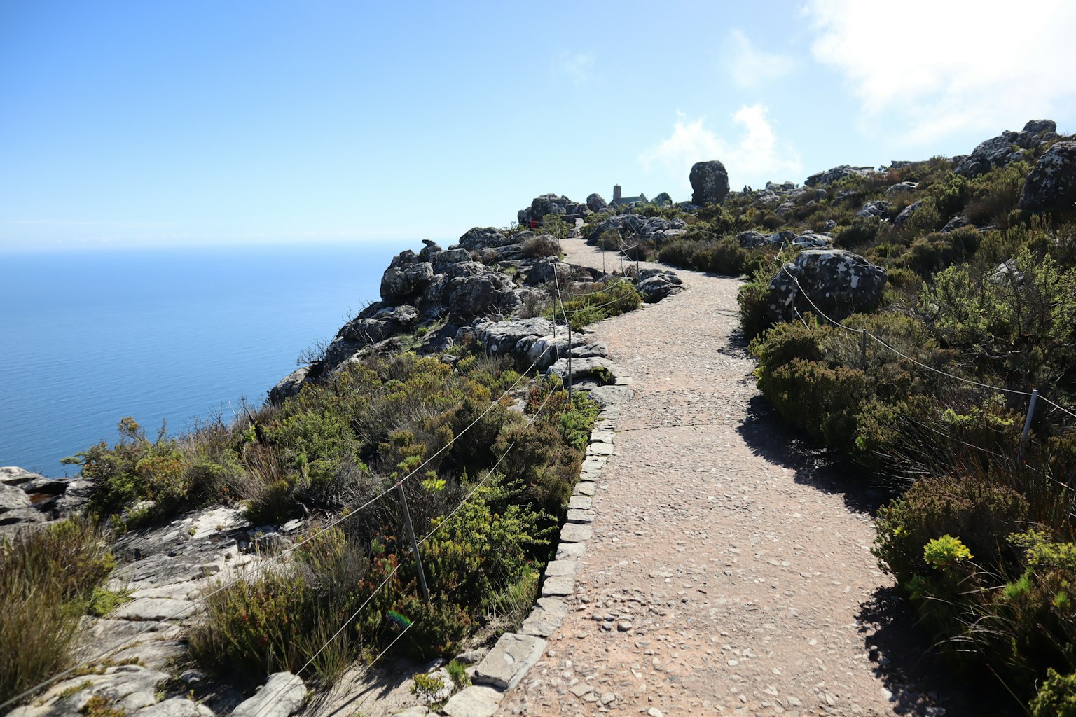 Camino escénico a lo largo de terreno rocoso con vistas al mar