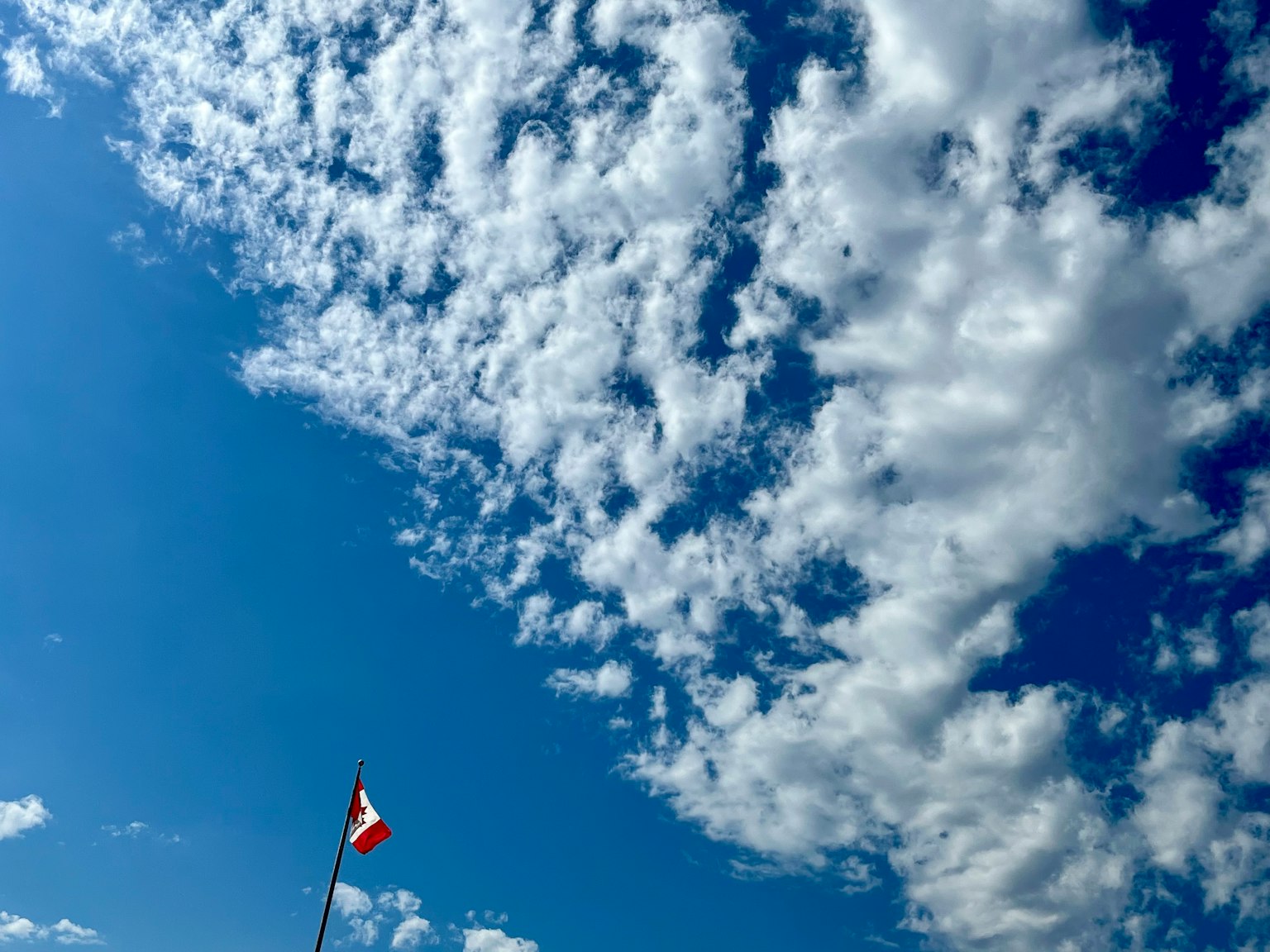 Ciel bleu rempli de nuages blancs et un drapeau mexicain flottant dans le vent
