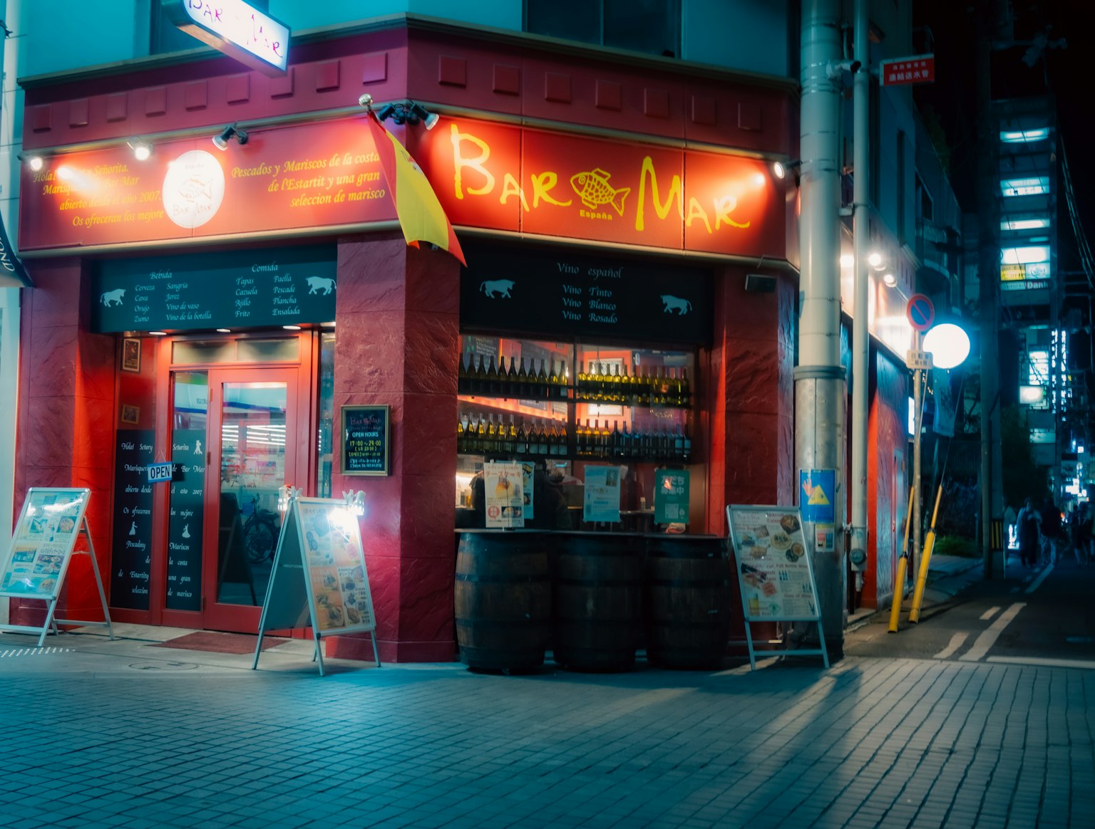 Außenansicht einer Bar und Weingeschäfts, beleuchtet in der Nacht
