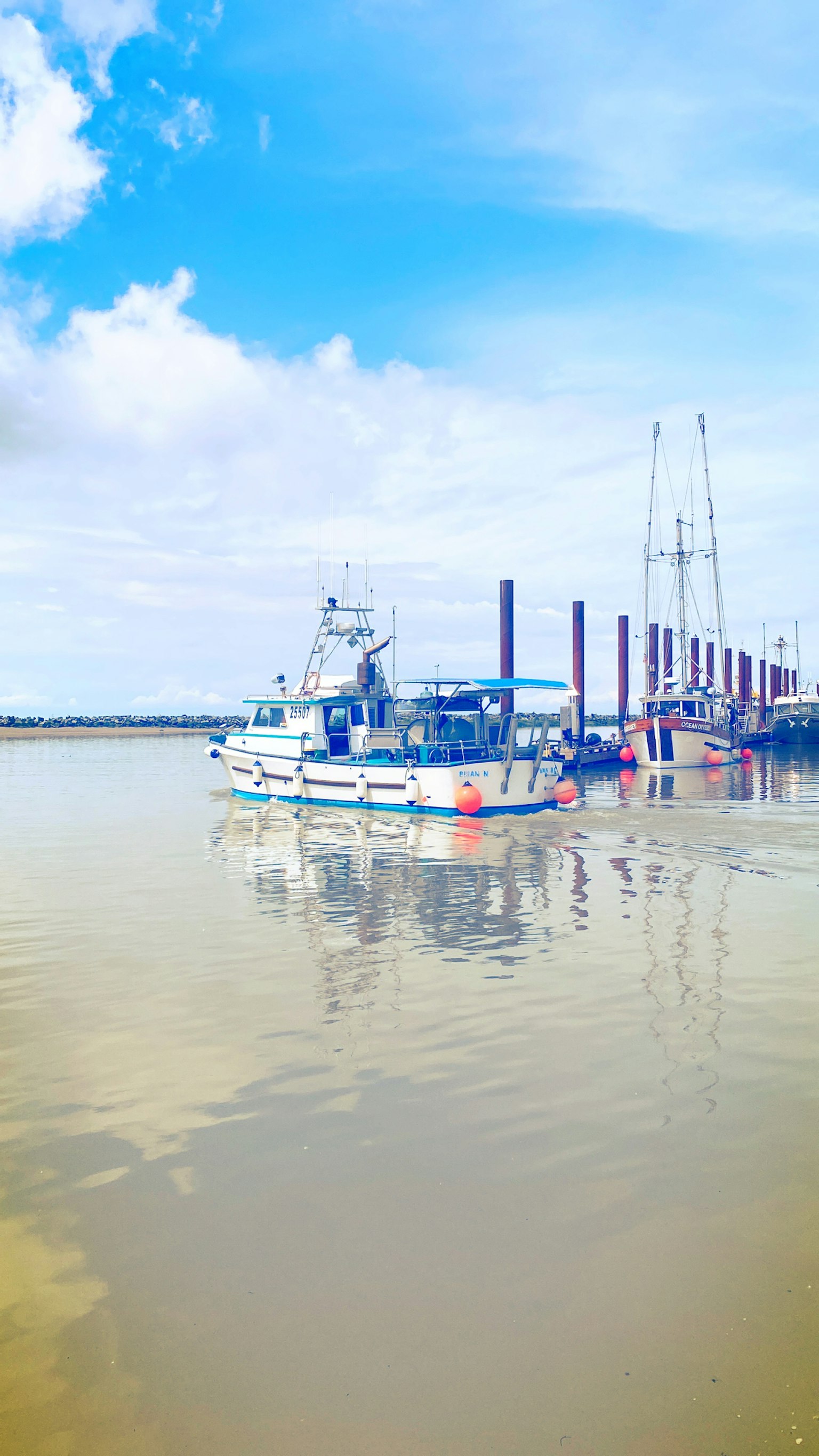 Bateau de pêche sur l'eau calme avec un quai en arrière-plan