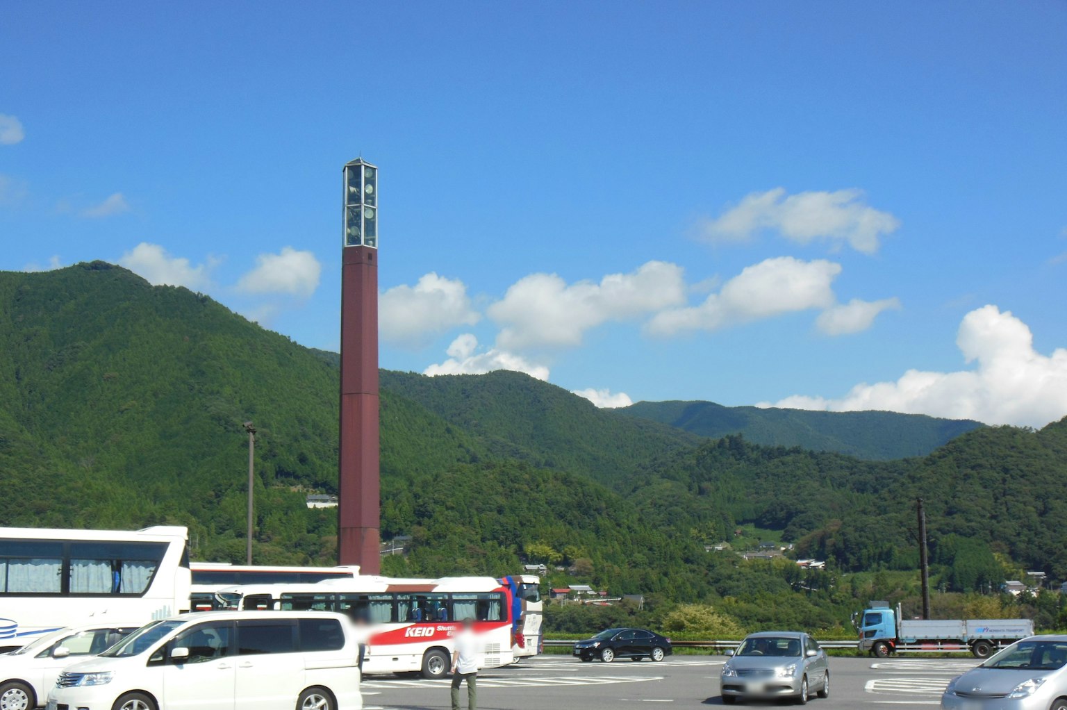 푸른 하늘 아래의 산과 전경에 있는 차량의 경치