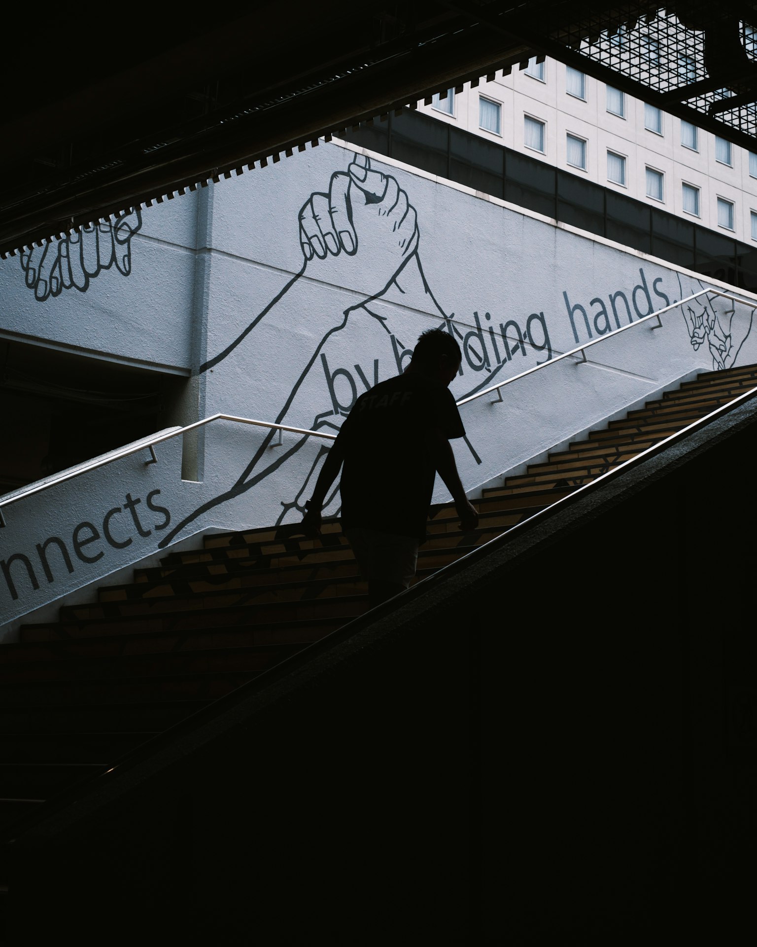 Silhouette d'une personne descendant des escaliers avec une œuvre graphique en arrière-plan