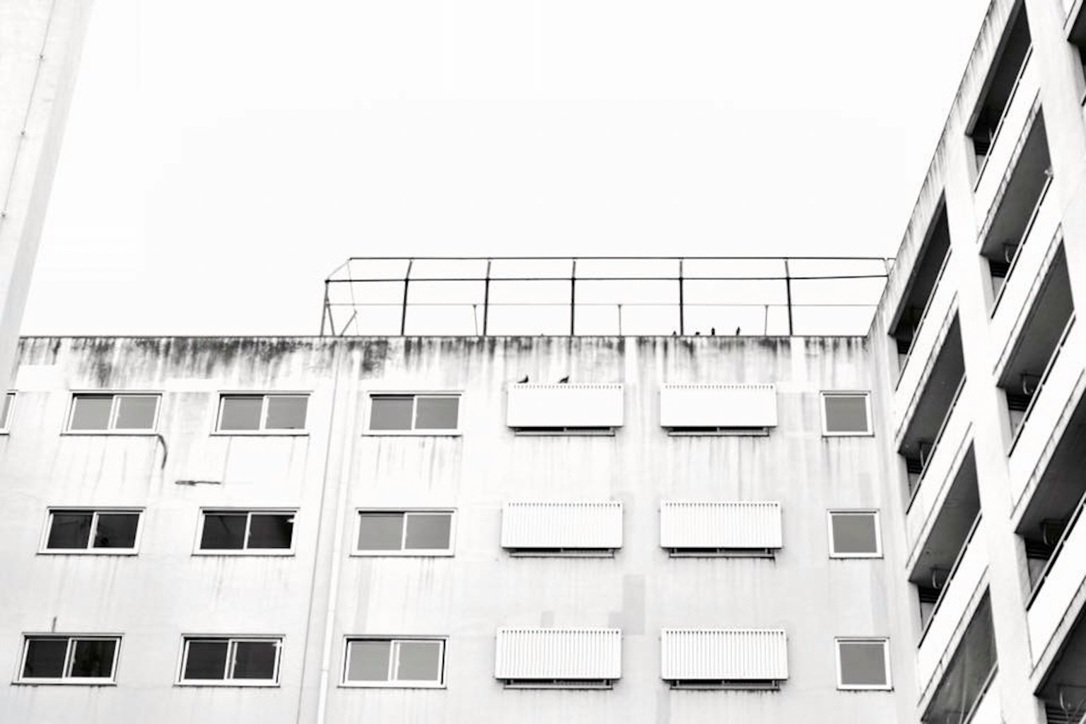 Immagine in bianco e nero della parte superiore di un edificio bianco con finestre