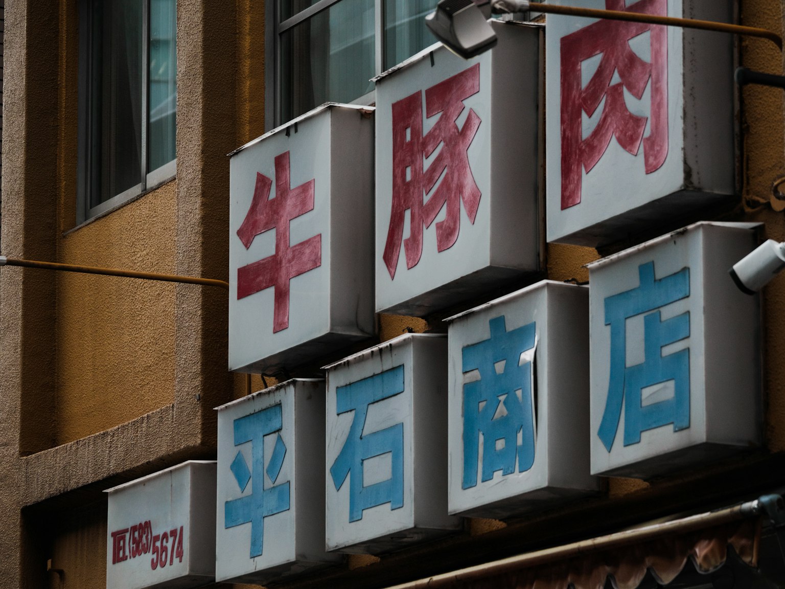 A corner of a shopping street with red and blue signs