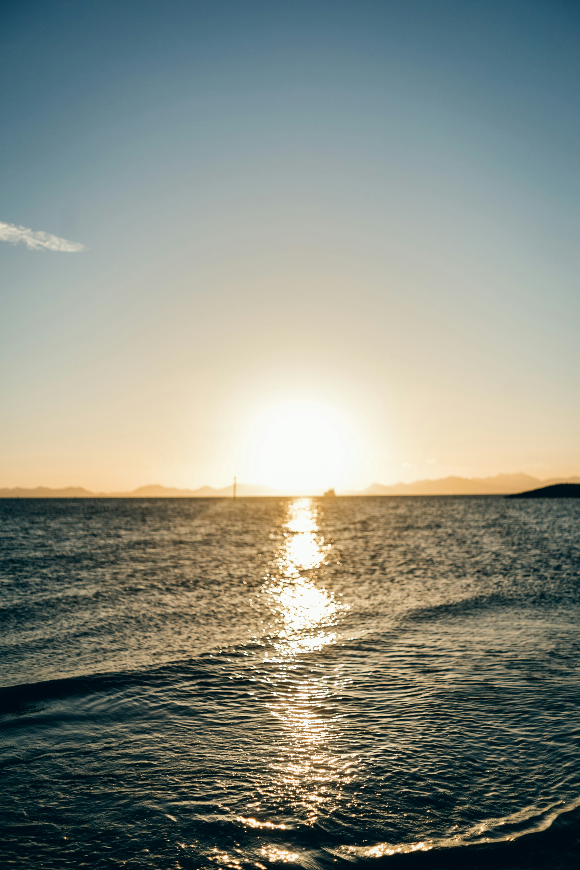 Sonnenuntergang am Horizont mit funkelnden Wellen auf dem Meer