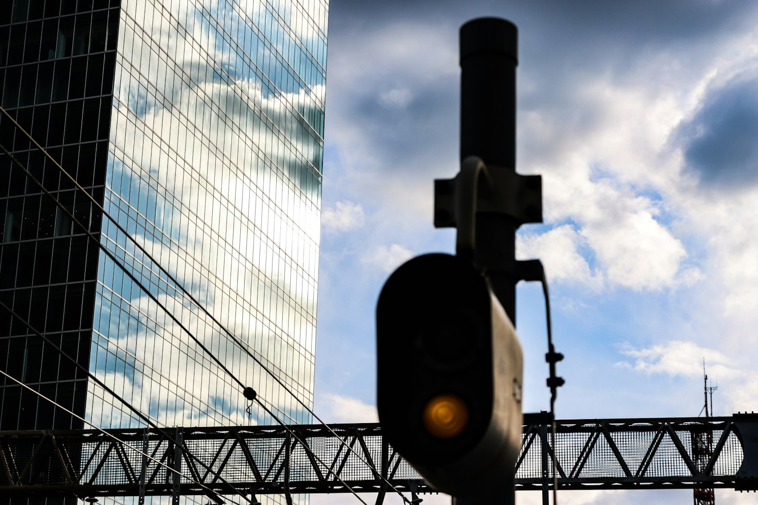 Silueta de una señal de tráfico frente a un rascacielos y un cielo azul